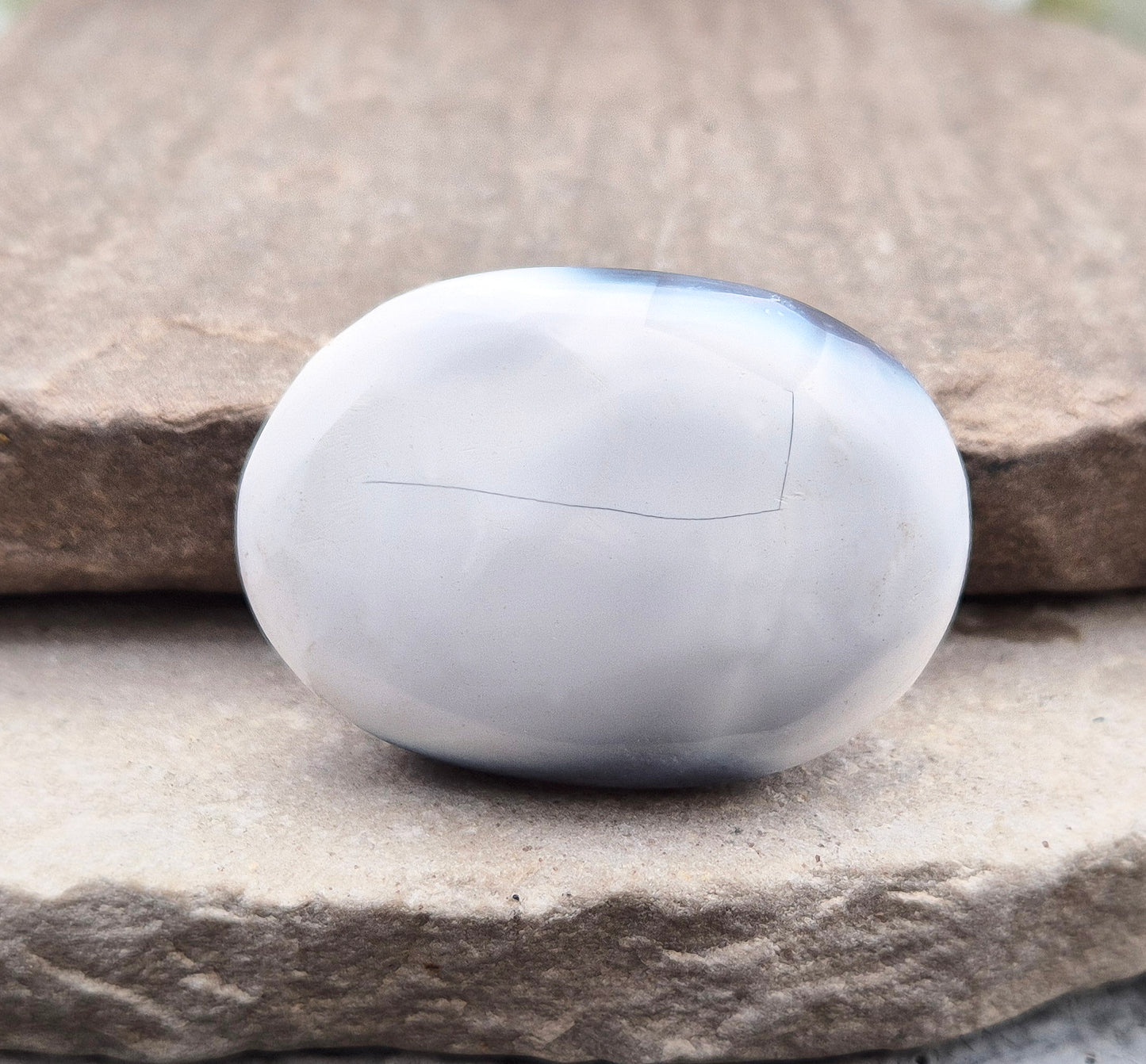 Polished Orca Agate (Grey Agate) galet with soft grey, white, and charcoal banding. A calming stone often chosen for emotional balance, grounding, and steady support.