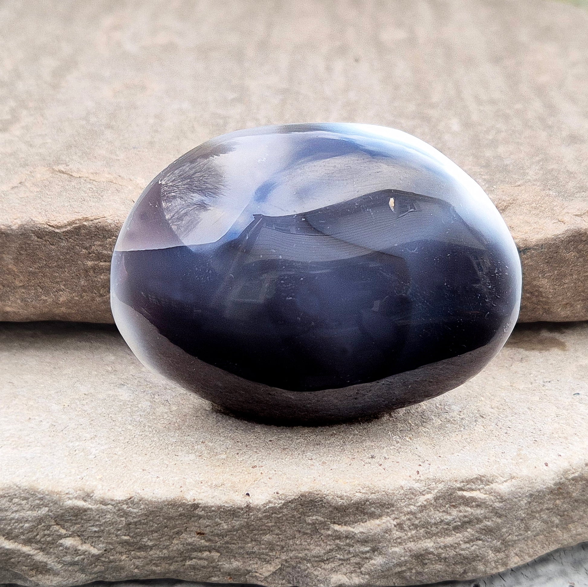 Polished Orca Agate (Grey Agate) galet with soft grey, white, and charcoal banding. A calming stone often chosen for emotional balance, grounding, and steady support.