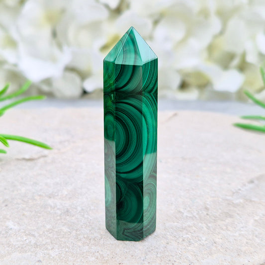 Malachite crystal tower from Congo with vivid green banding. Known as a powerful protection stone for transformation, courage, and personal growth.
