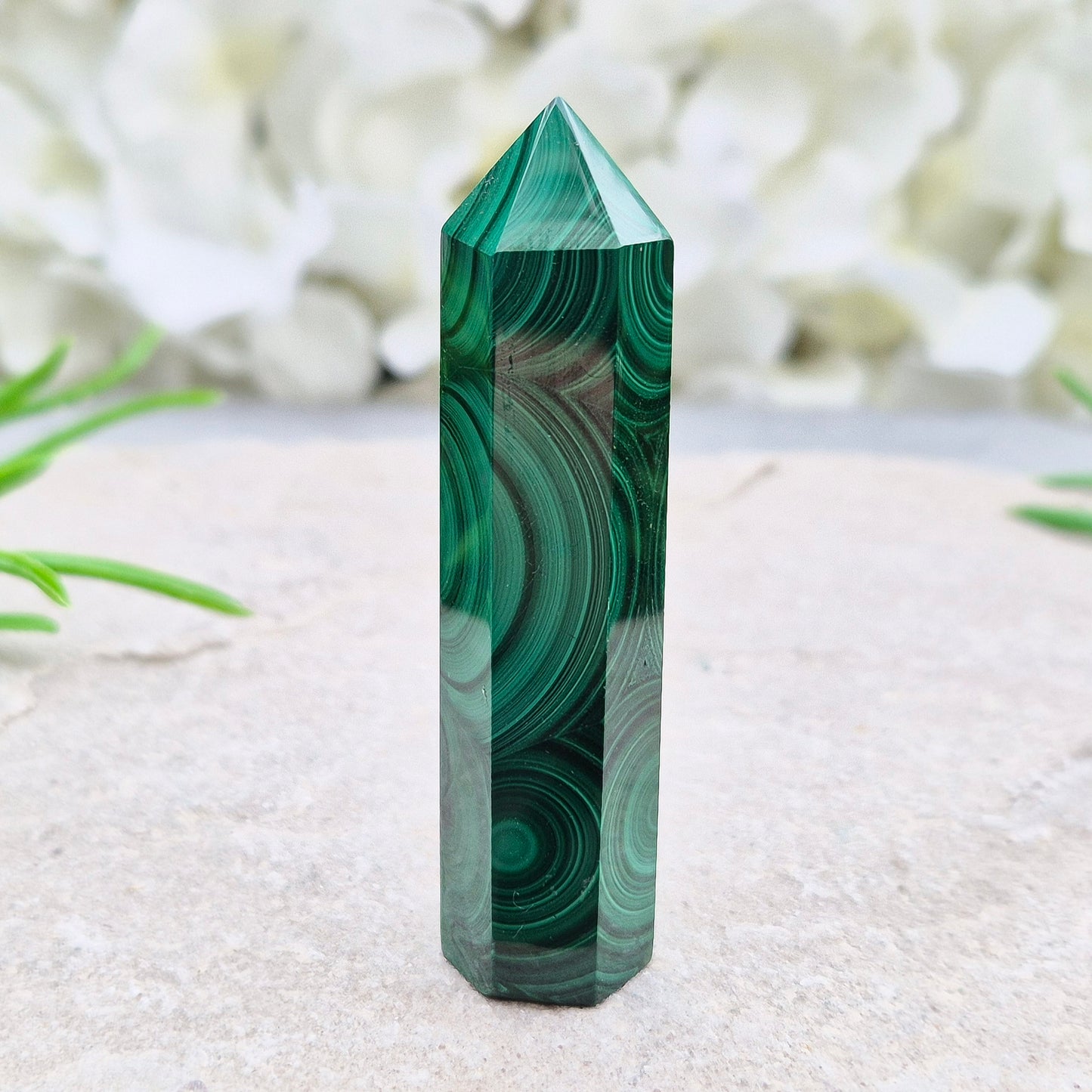 Malachite crystal tower from Congo with vivid green banding. Known as a powerful protection stone for transformation, courage, and personal growth.