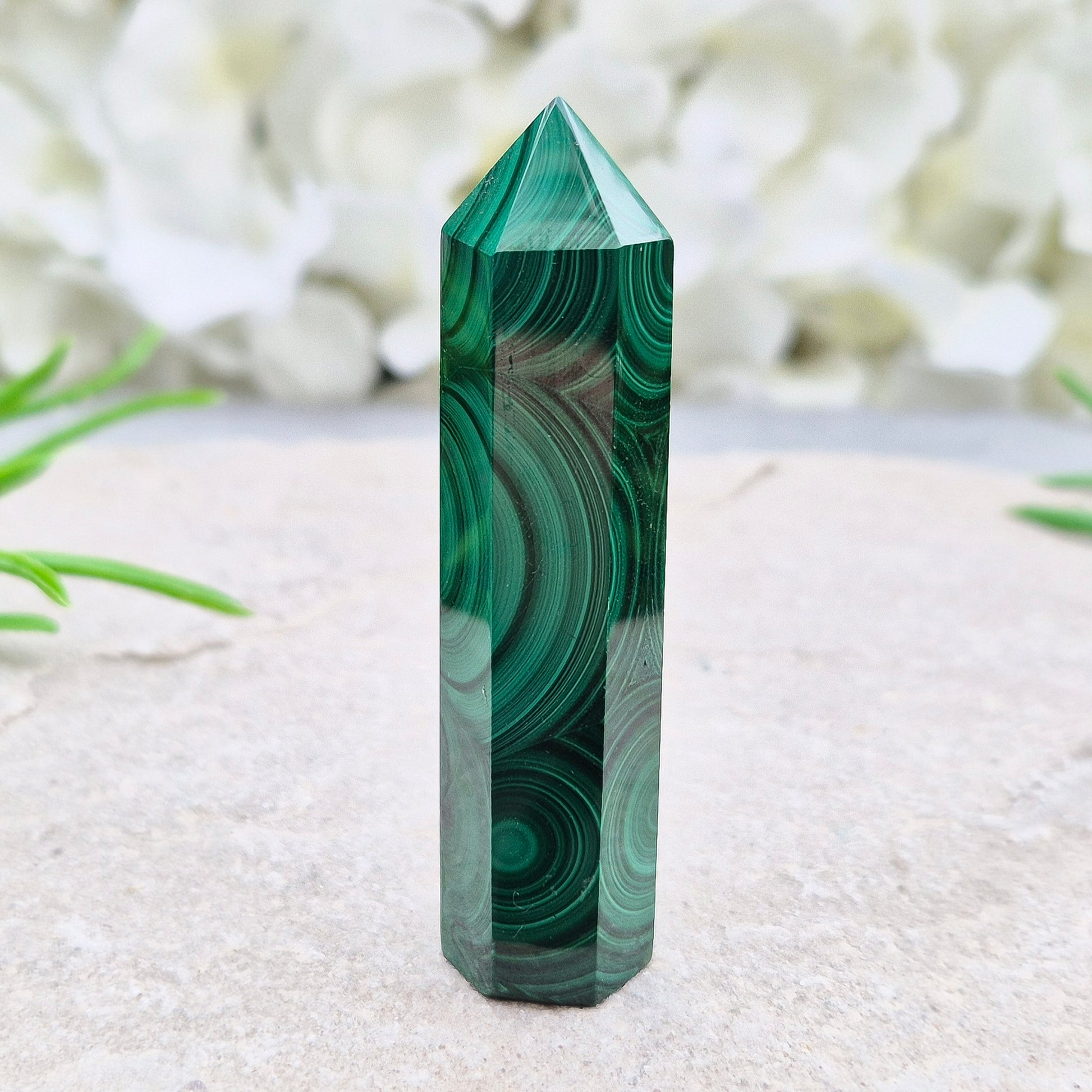 Malachite crystal tower from Congo with vivid green banding. Known as a powerful protection stone for transformation, courage, and personal growth.