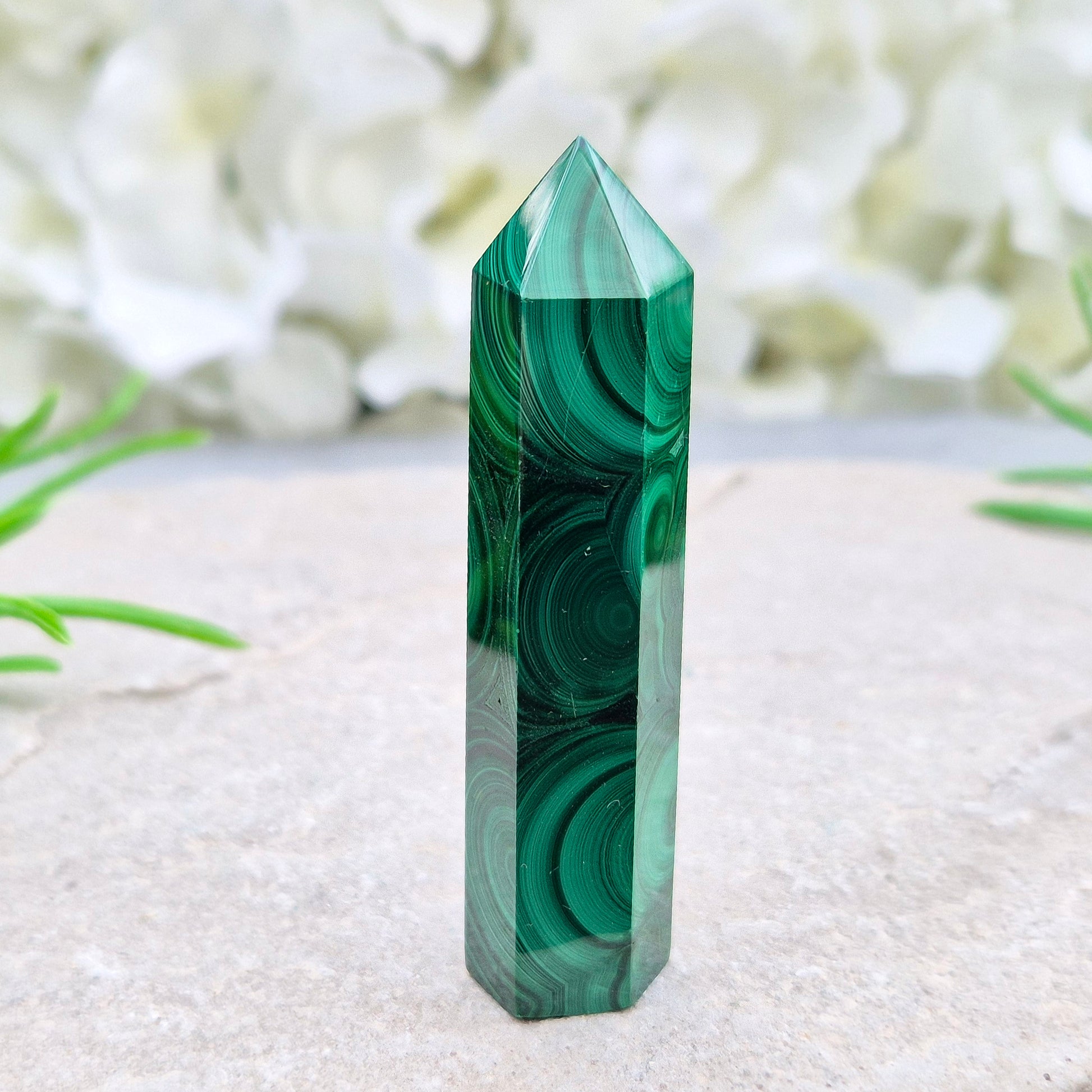 Malachite crystal tower from Congo with vivid green banding. Known as a powerful protection stone for transformation, courage, and personal growth.
