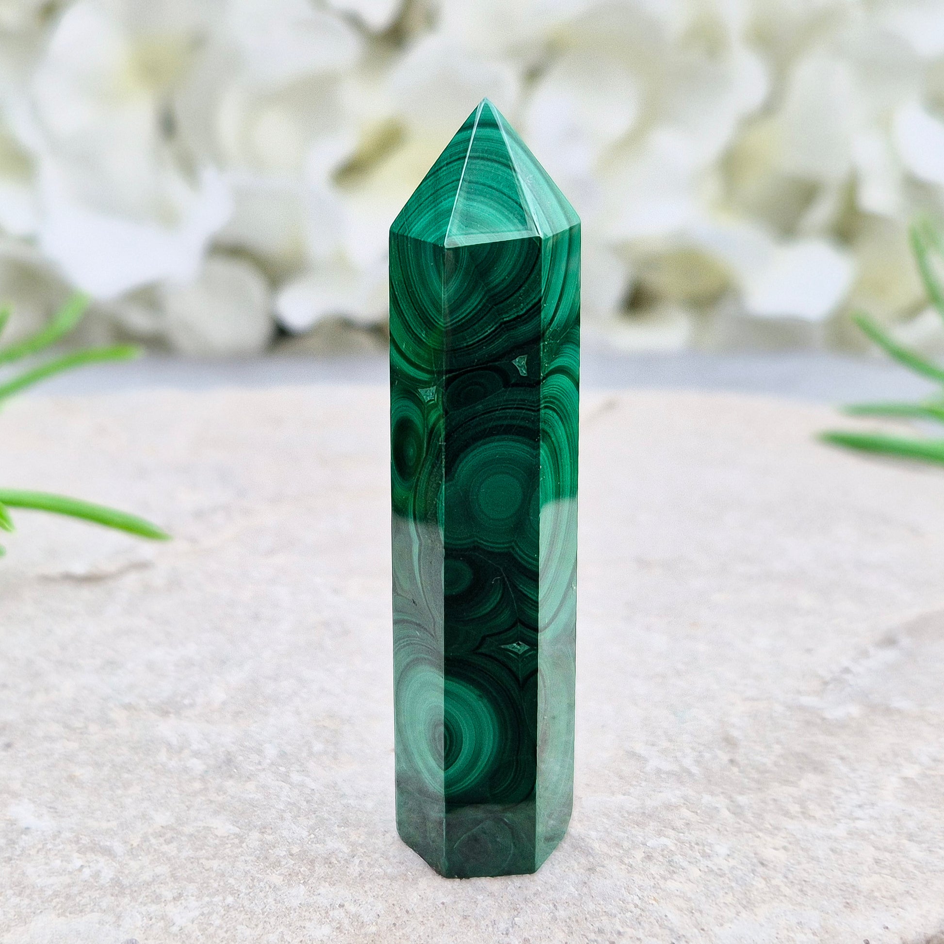 Malachite crystal tower from Congo with vivid green banding. Known as a powerful protection stone for transformation, courage, and personal growth.