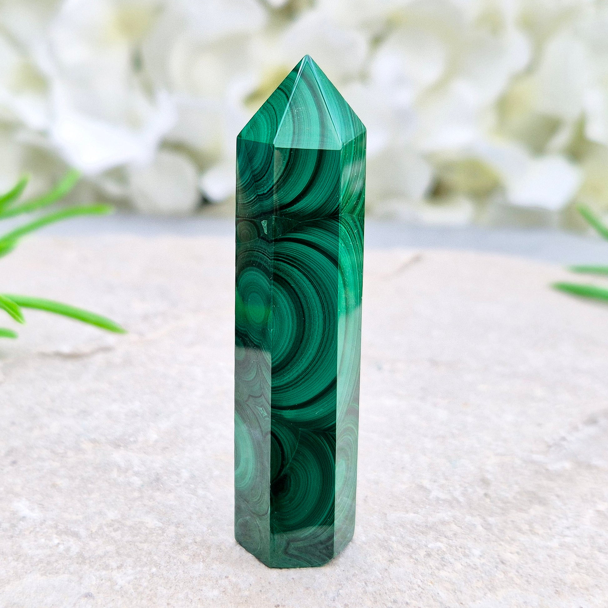 Malachite crystal tower from Congo with vivid green banding. Known as a powerful protection stone for transformation, courage, and personal growth.