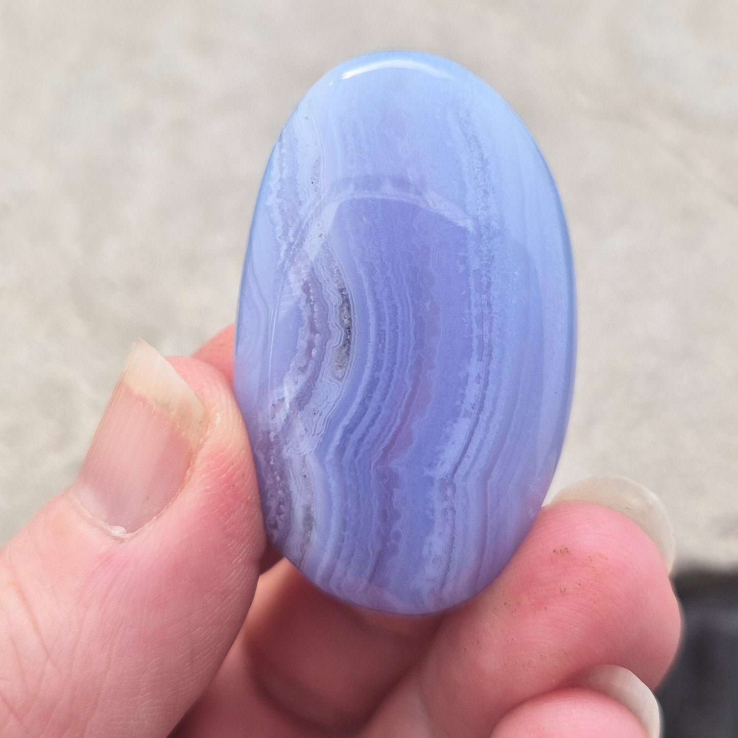 Polished Blue Lace Agate crystal palm stone with wonderful banding. A calming crystal, ideal for relaxation, clear communication and gentle healing.