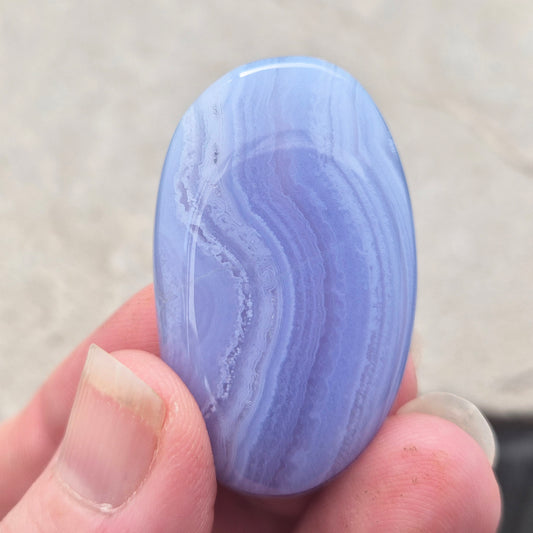 Polished Blue Lace Agate crystal palm stone with wonderful banding. A calming crystal, ideal for relaxation, clear communication and gentle healing.