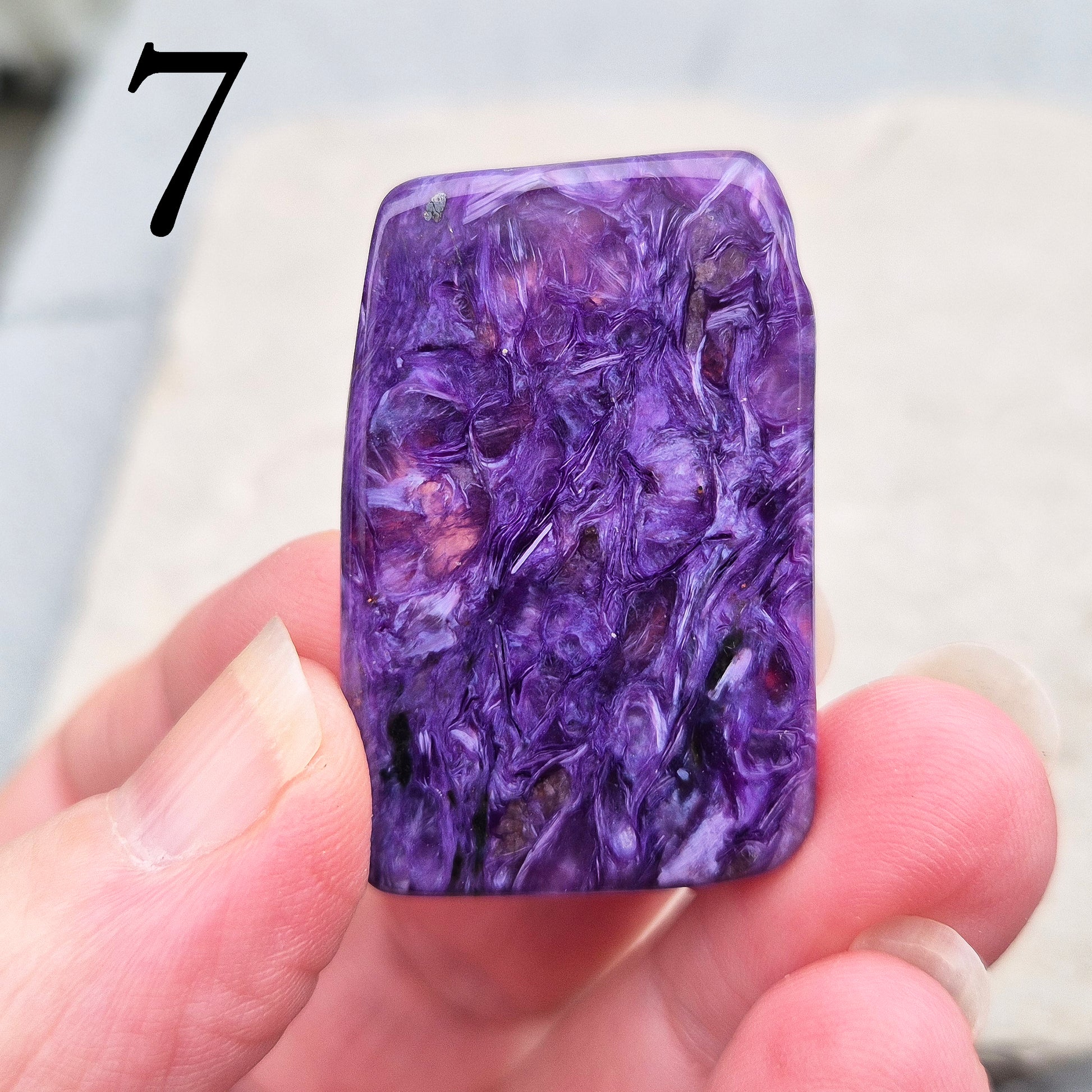 Polished Charoite slice with rich purple swirling patterns. A striking crystal associated with transformation, emotional strength, and personal growth.