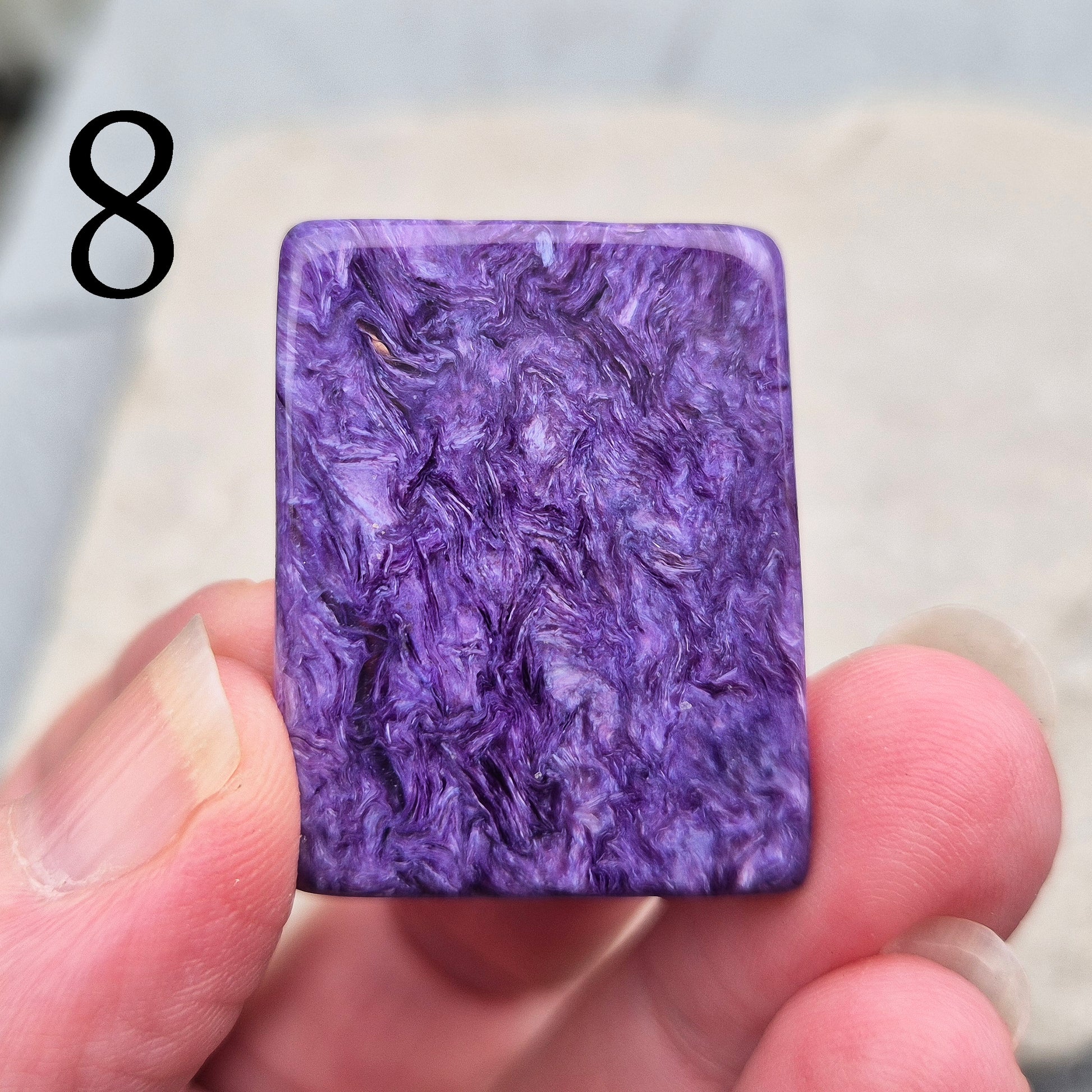 Polished Charoite slice with rich purple swirling patterns. A striking crystal associated with transformation, emotional strength, and personal growth.
