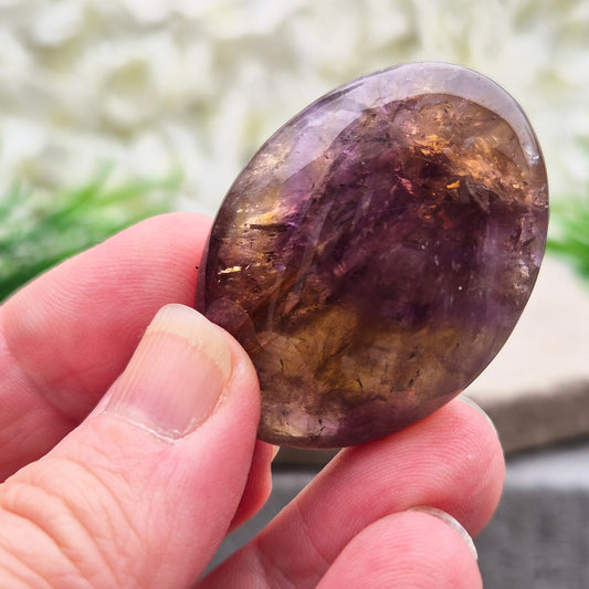Natural Ametrine palm stone with subtle colour mix and organic inclusions. A smooth, easy-to-hold crystal for focus, balance, and direction.v