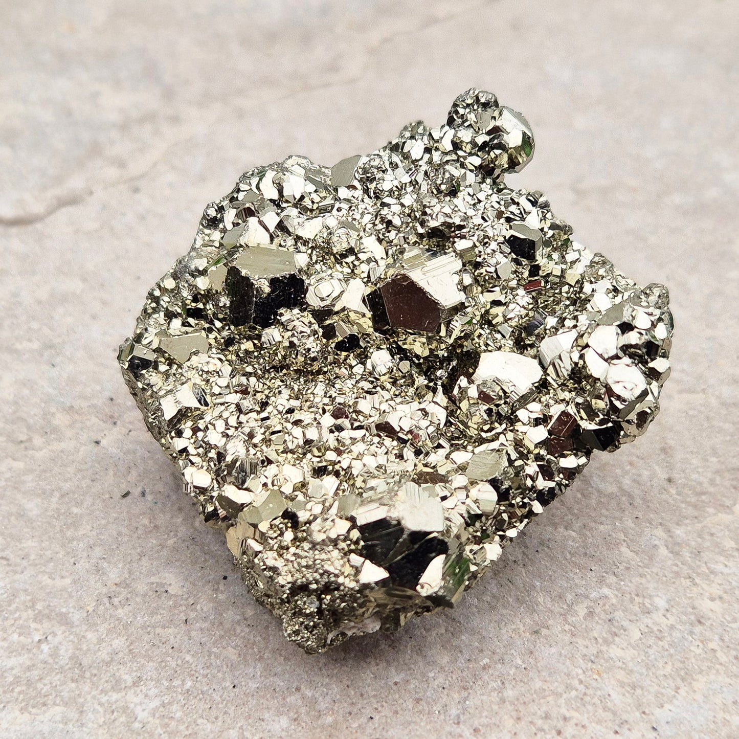 Natural pyrite crystal cluster from Peru featuring defined cubes and rich gold lustre. A striking, light-catching piece for home decor, desks, or crystal lovers.