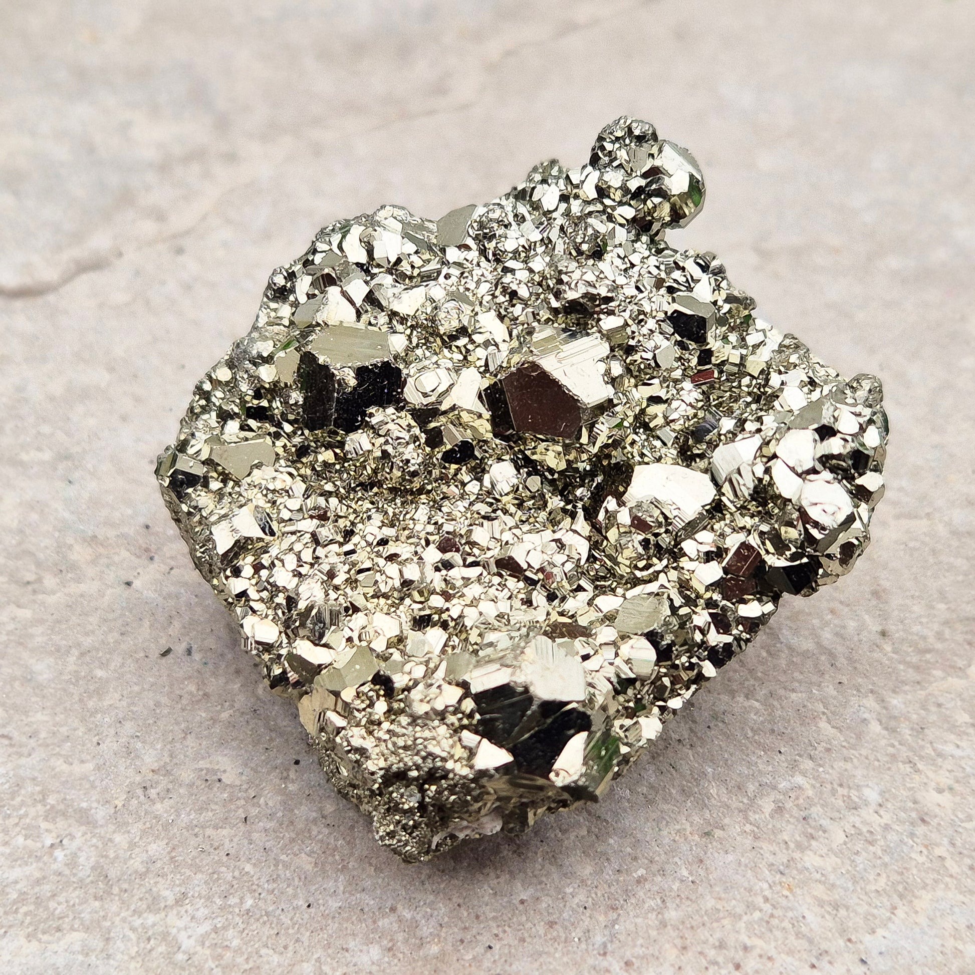 Natural pyrite crystal cluster from Peru featuring defined cubes and rich gold lustre. A striking, light-catching piece for home decor, desks, or crystal lovers.