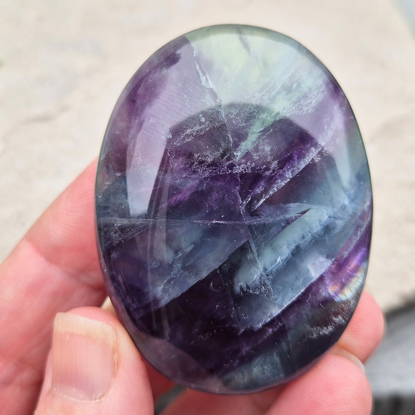 Rainbow Fluorite palm stone for focus and balance. Polished banded crystal to calm the mind, support clear thinking and ease overwhelm.