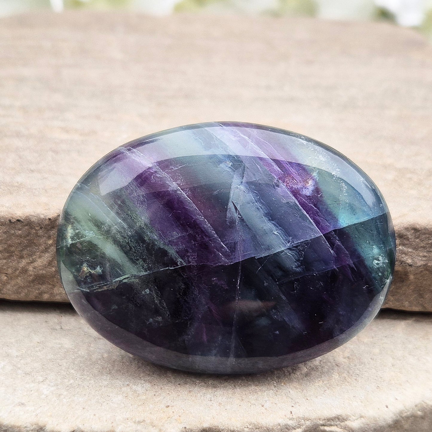 Rainbow Fluorite palm stone for focus and balance. Polished banded crystal to calm the mind, support clear thinking and ease overwhelm.