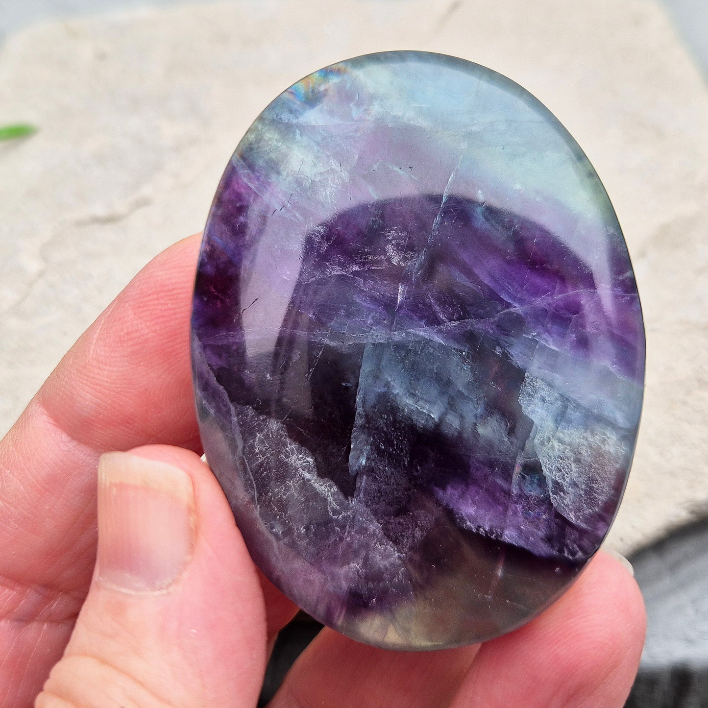 Rainbow Fluorite palm stone for focus and balance. Polished banded crystal to calm the mind, support clear thinking and ease overwhelm.