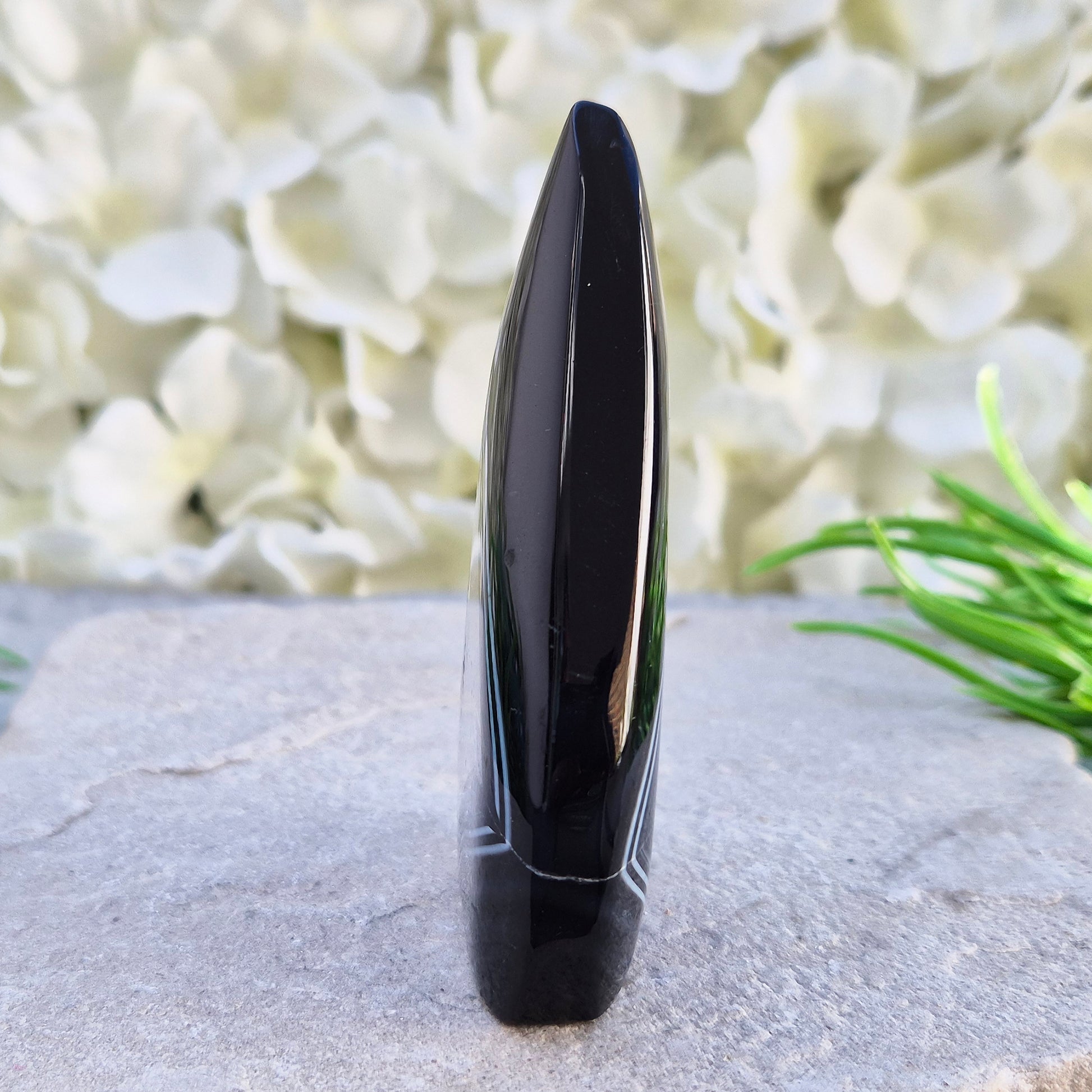 Polished black agate and quartz crystal flame from Brazil, traditionally associated with grounding and balance. A striking natural stone.