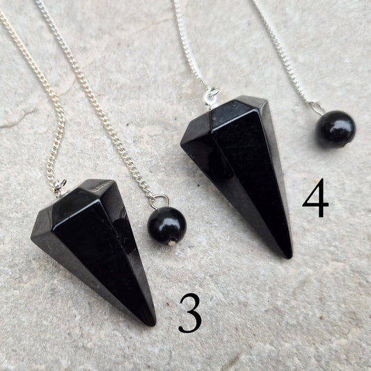 Natural Black Tourmaline crystal pendulum for dowsing, divination, and spiritual work. A grounding stone linked with protection and balance.