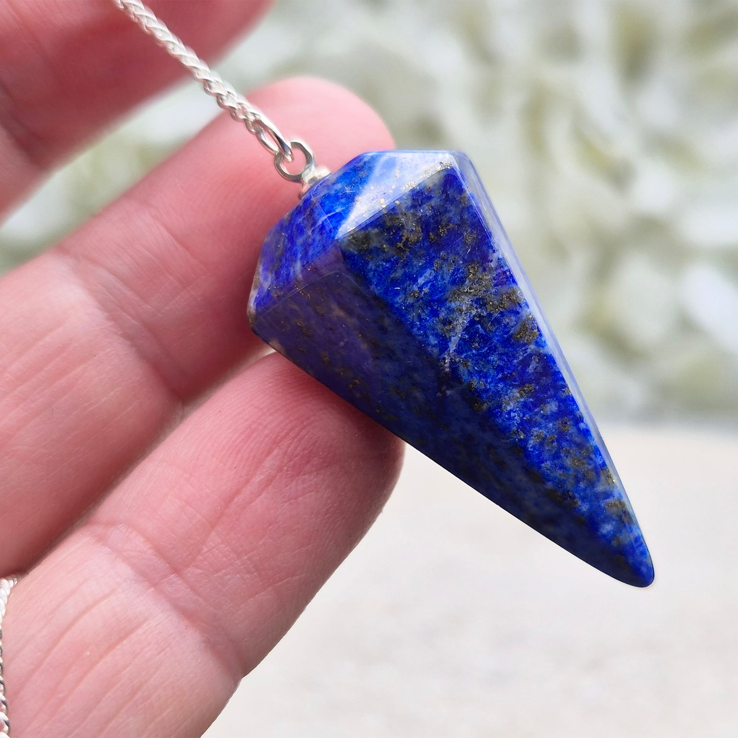 Lapis lazuli pendulum for divination and intuition work. A deep blue crystal pendulum used for guidance, energy reading, and spiritual focus.