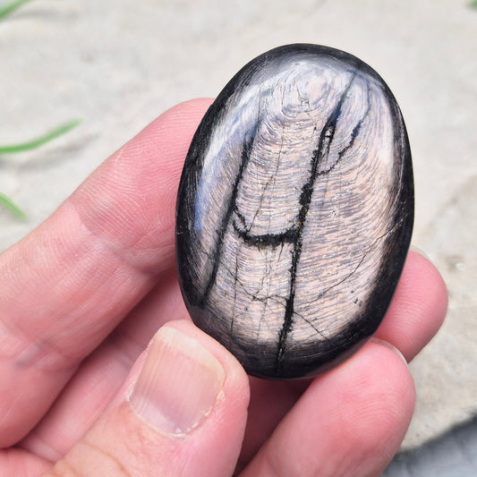 Violet Hypersthene palm stone with a smooth, comforting feel. A grounding crystal often chosen for inner strength, calm focus, and quiet self-reflection.
