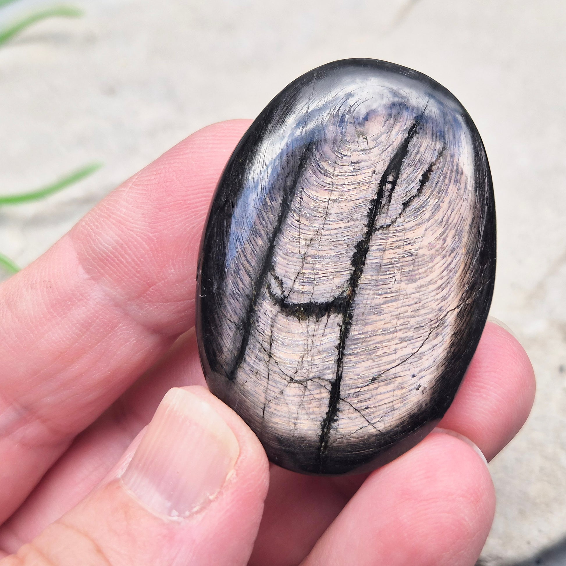 Violet Hypersthene palm stone with a smooth, comforting feel. A grounding crystal often chosen for inner strength, calm focus, and quiet self-reflection.