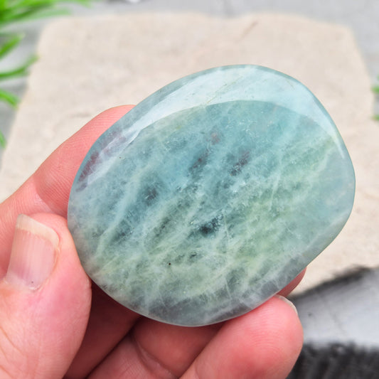 Shop polished Aquamarine palm stones — calming, water-toned crystals known for supporting clear communication. A thoughtful gift for anyone facing a stressful time.