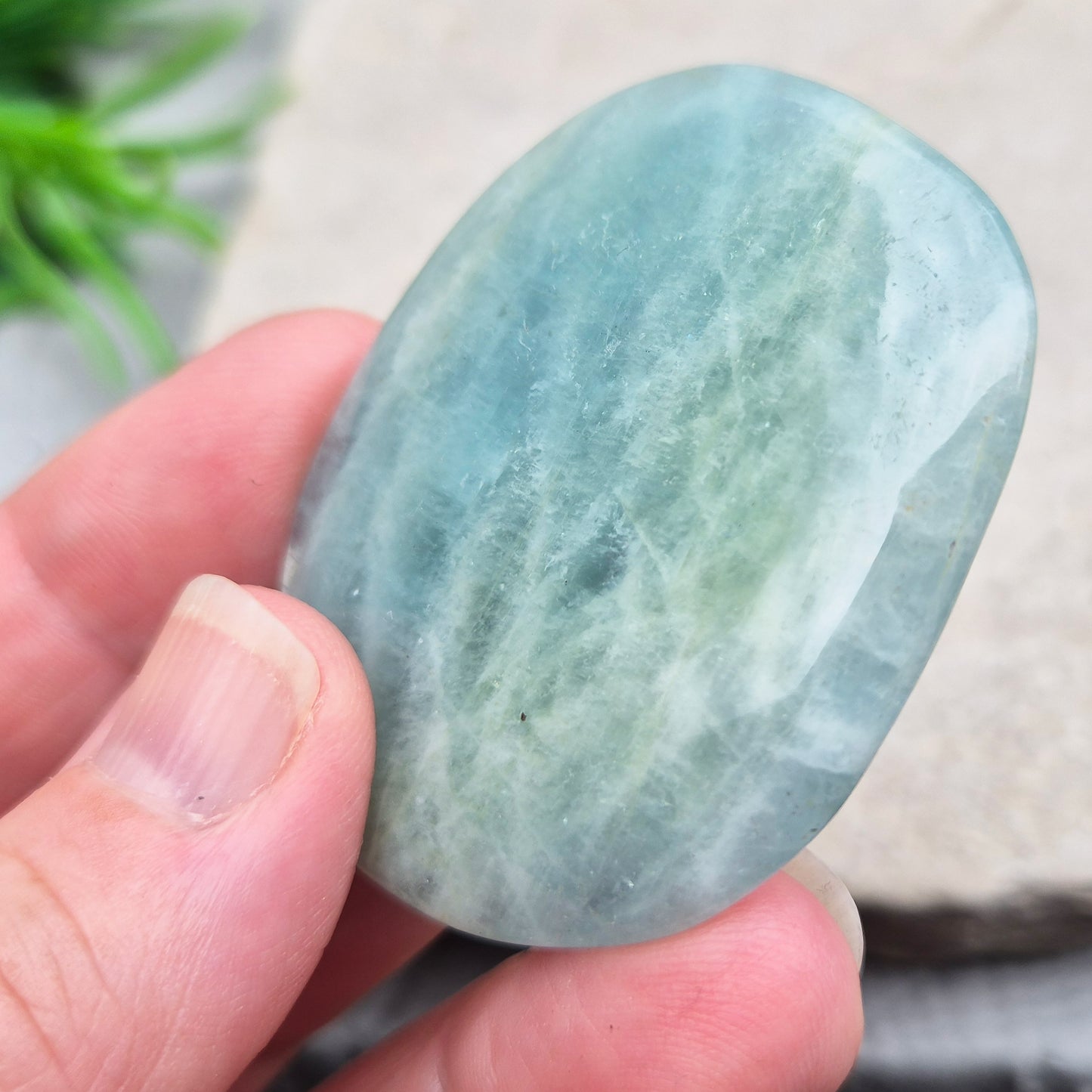 Shop polished Aquamarine palm stones — calming, water-toned crystals known for supporting clear communication. A thoughtful gift for anyone facing a stressful time.