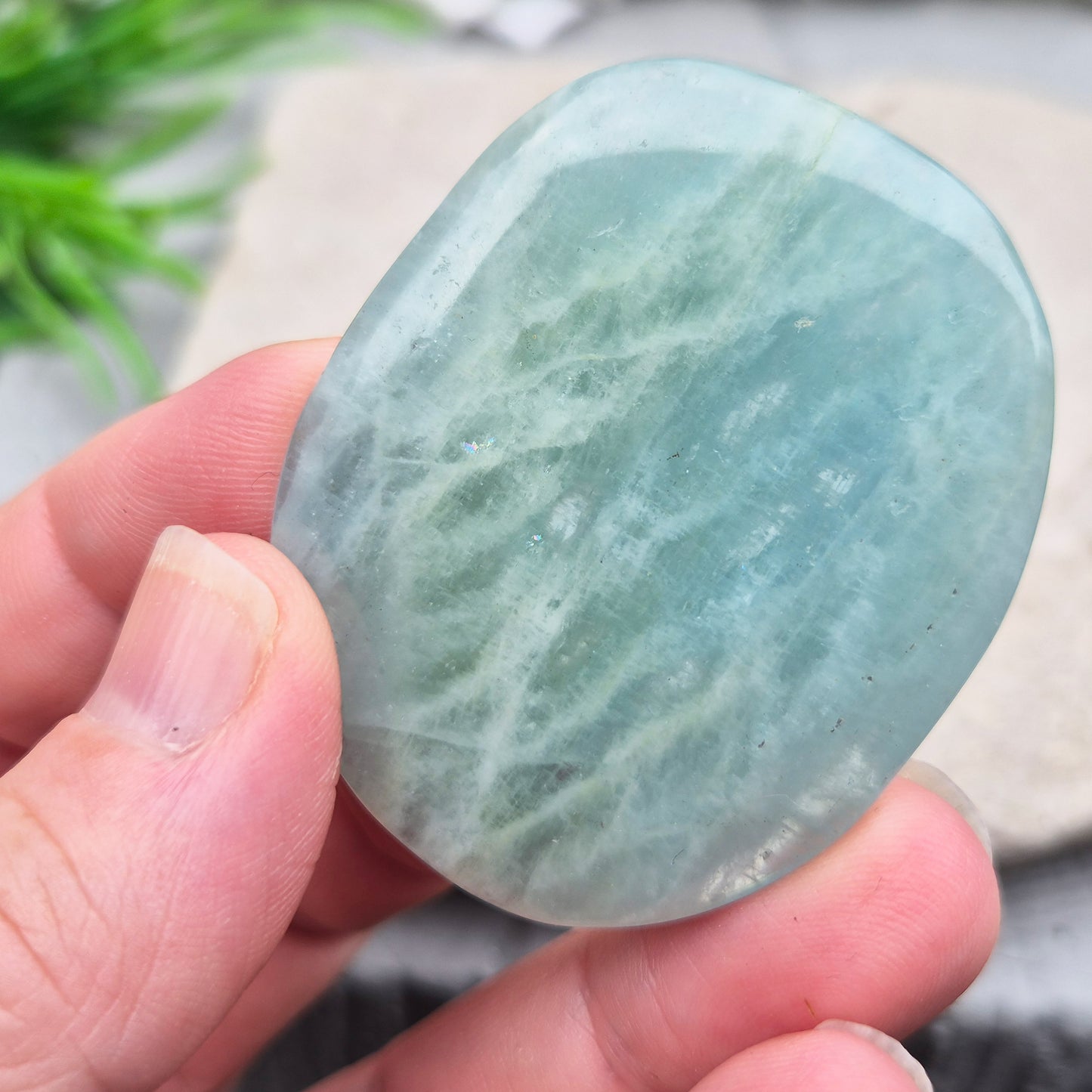 Shop polished Aquamarine palm stones — calming, water-toned crystals known for supporting clear communication. A thoughtful gift for anyone facing a stressful time.
