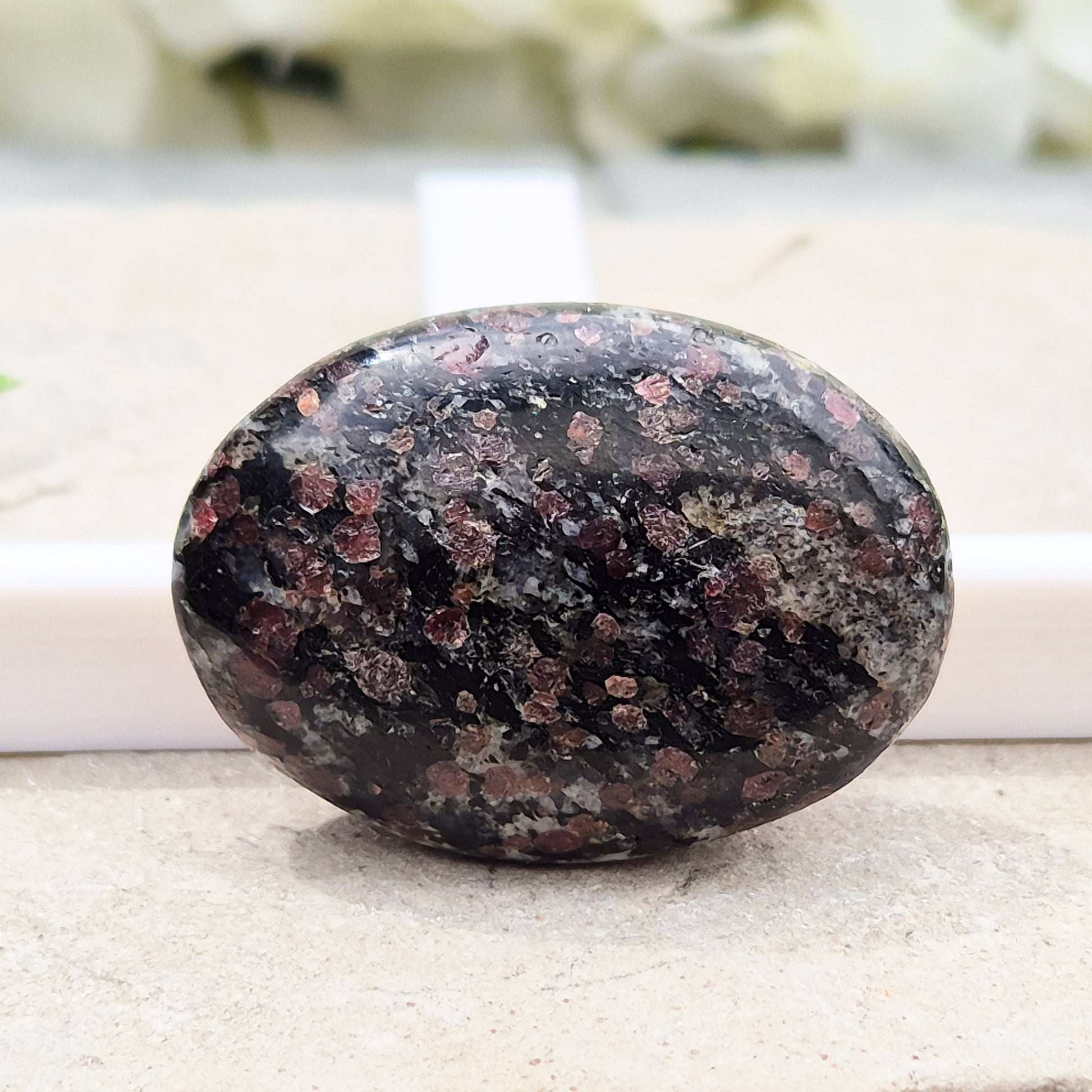 red Garnet in Black Tourmaline palm stone — naturally formed, said to bring grounding, courage and inner strength. Shop UK crystals at Elysian Crystals.