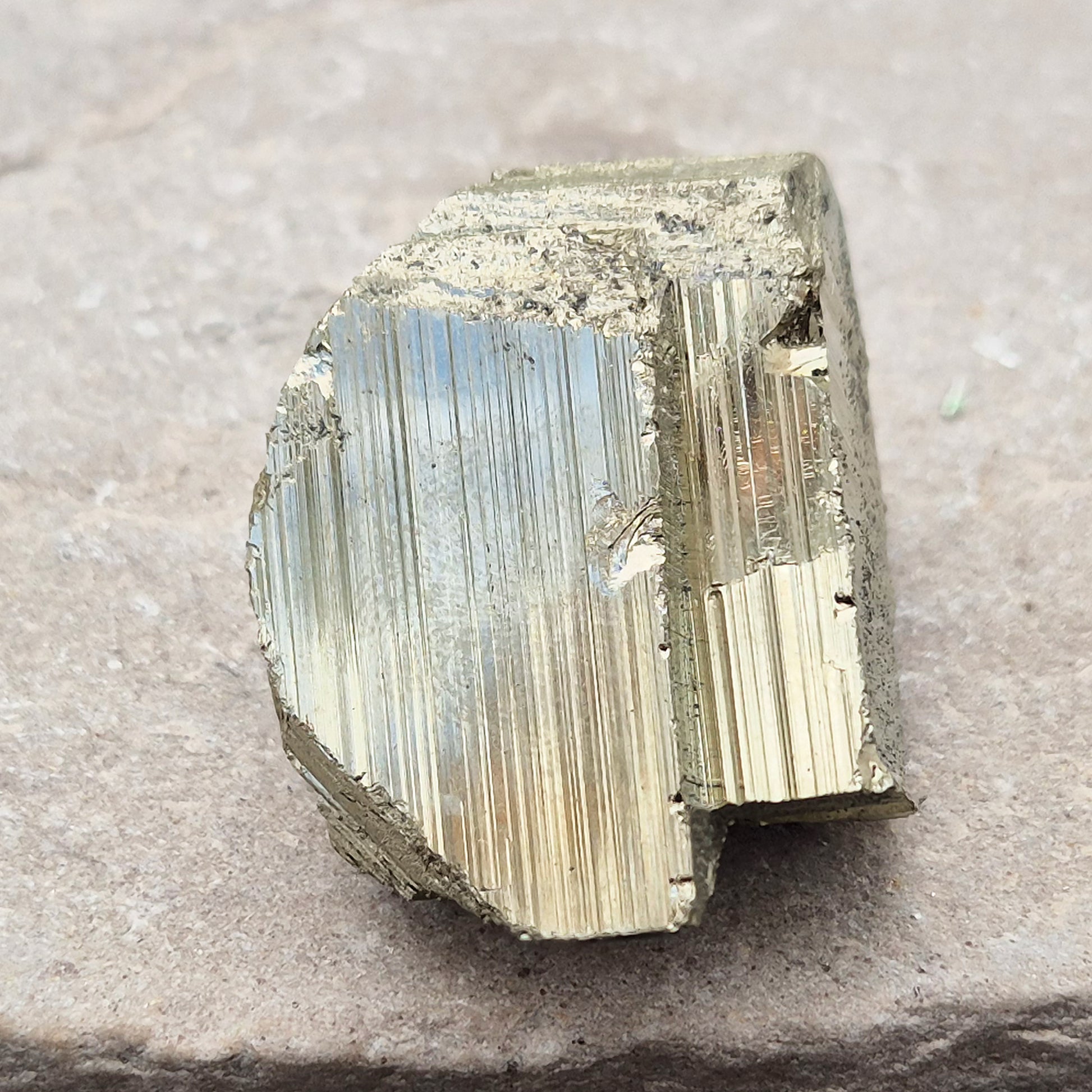 Pyrite specimen with striated face and bright metallic shine. Sparkling smooth and natural texture, ideal for display, grounding energy, or crystal collections.