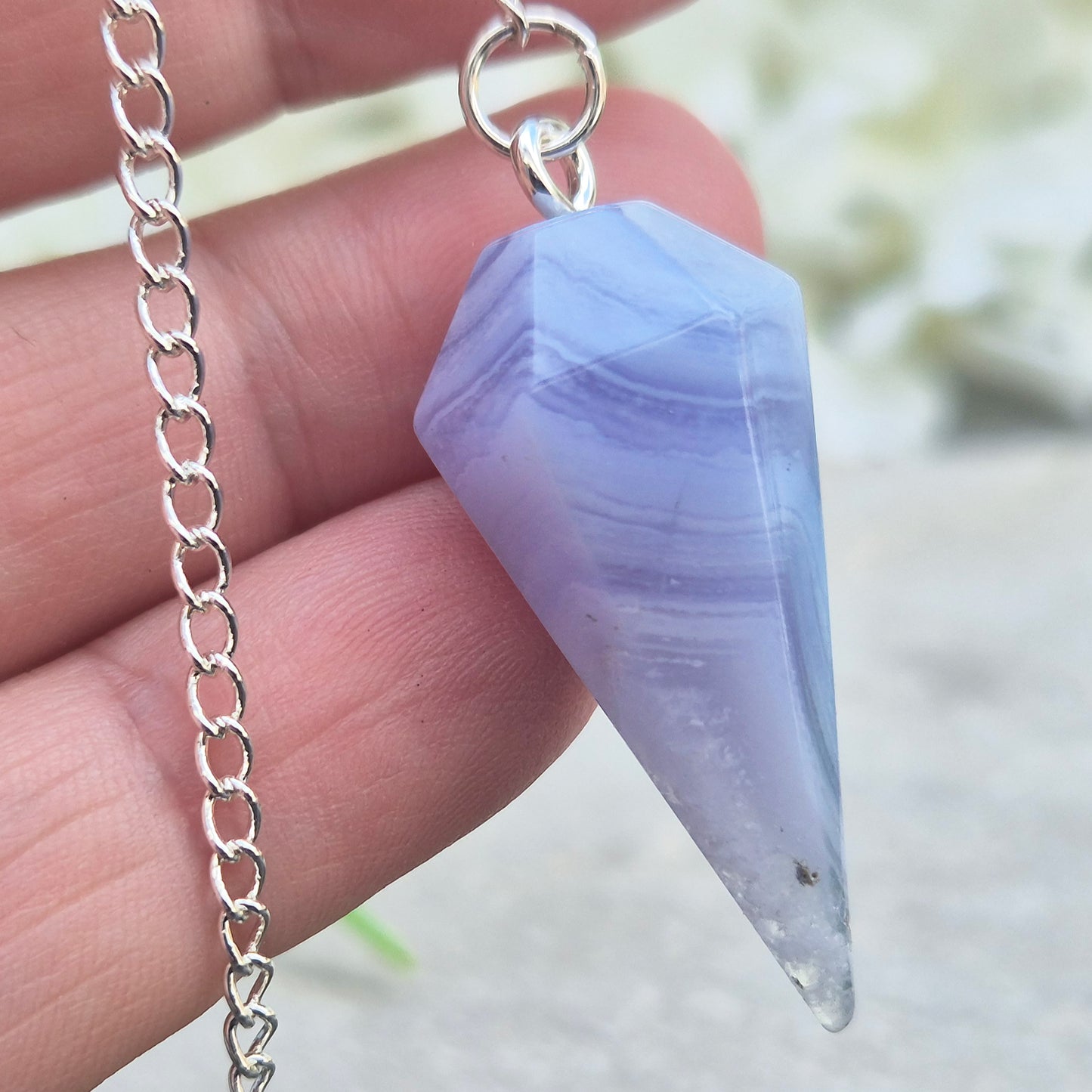 Blue Lace Agate crystal pendulum, known for its calming energy. Ideal for dowsing, spiritual guidance, and bringing a steady, peaceful feel.