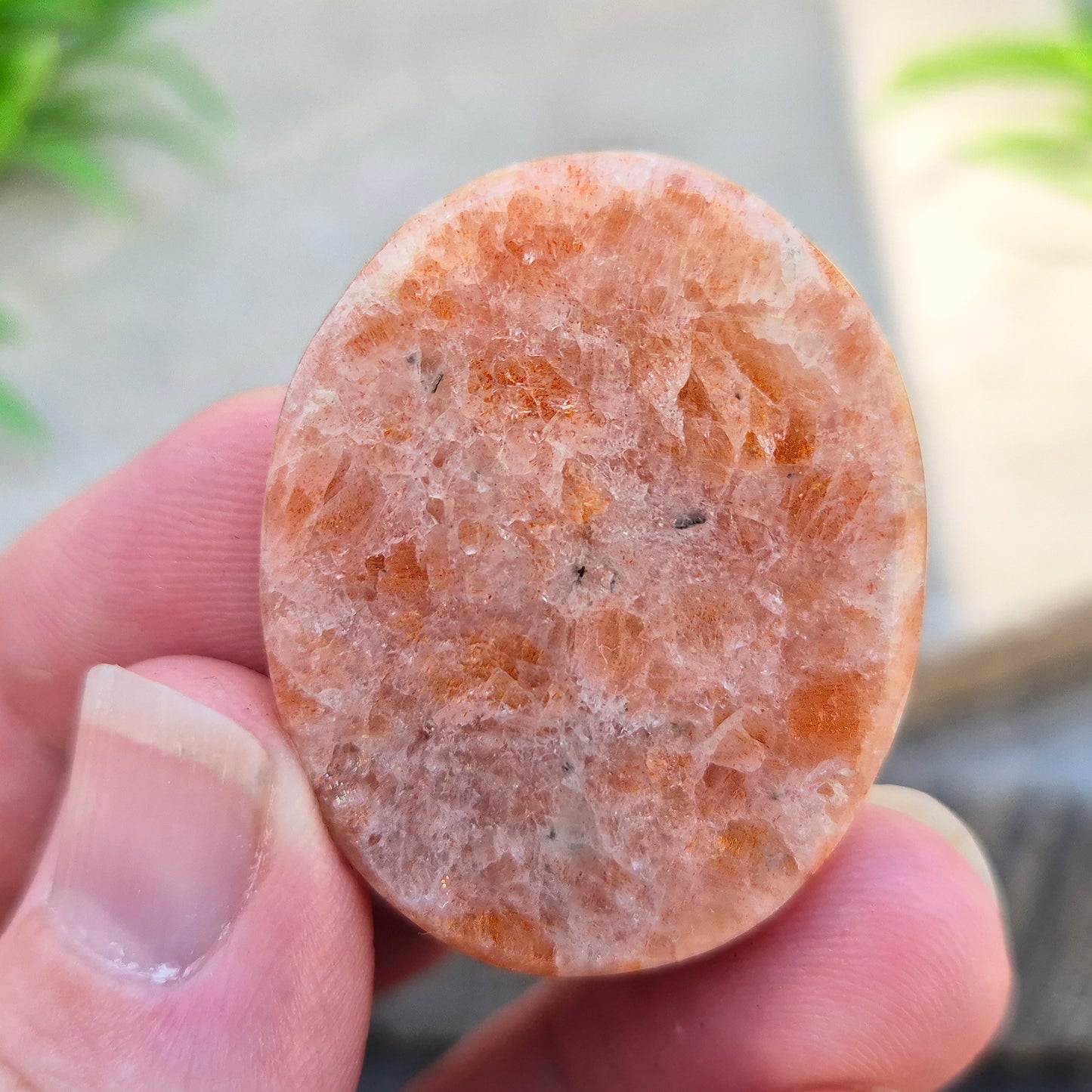 This flat, oval Sunstone palm stone carries soft peachy-orange tones and sits smoothly in the hand. Small enough to slip into a pocket or bag — sunshine you can carry with you.
