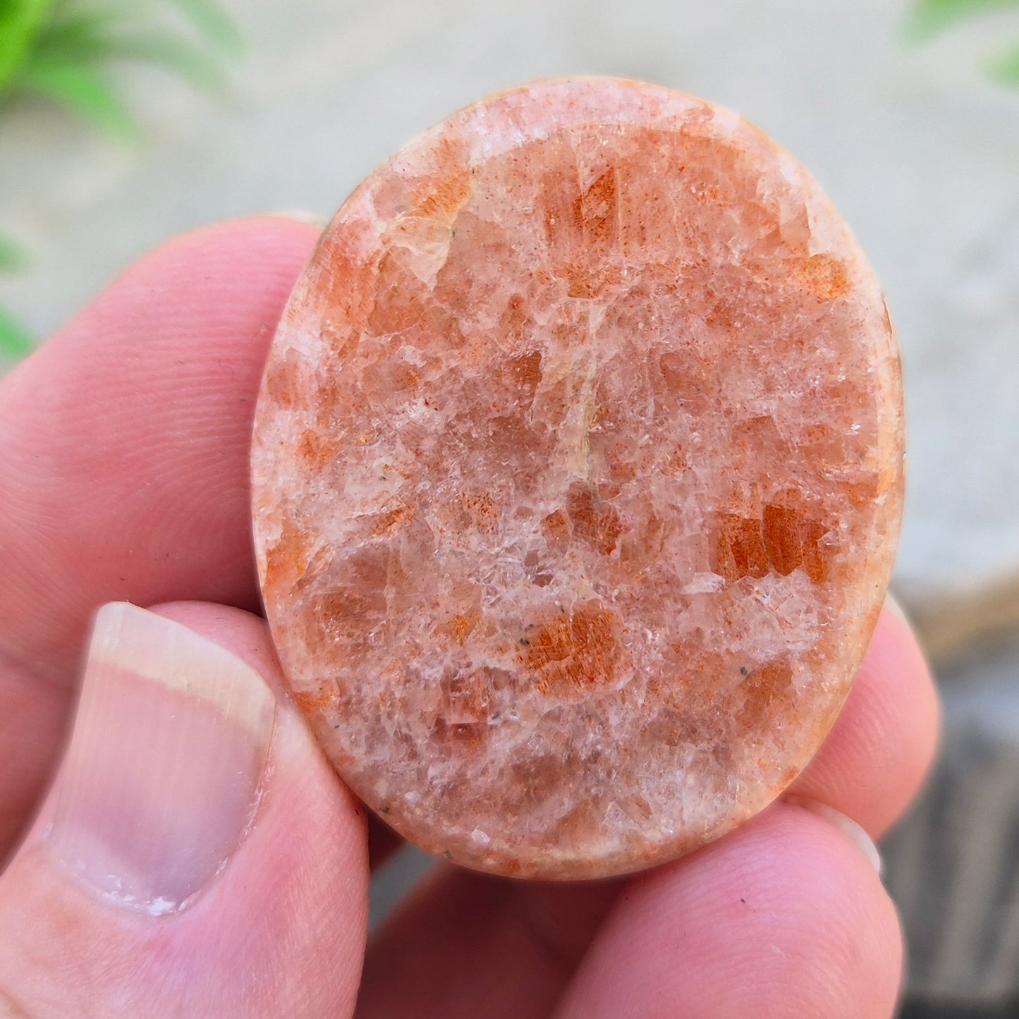 This flat, oval Sunstone palm stone carries soft peachy-orange tones and sits smoothly in the hand. Small enough to slip into a pocket or bag — sunshine you can carry with you.