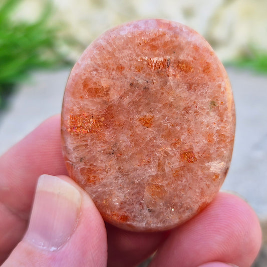 This flat, oval Sunstone palm stone carries soft peachy-orange tones and sits smoothly in the hand. Small enough to slip into a pocket or bag — sunshine you can carry with you.