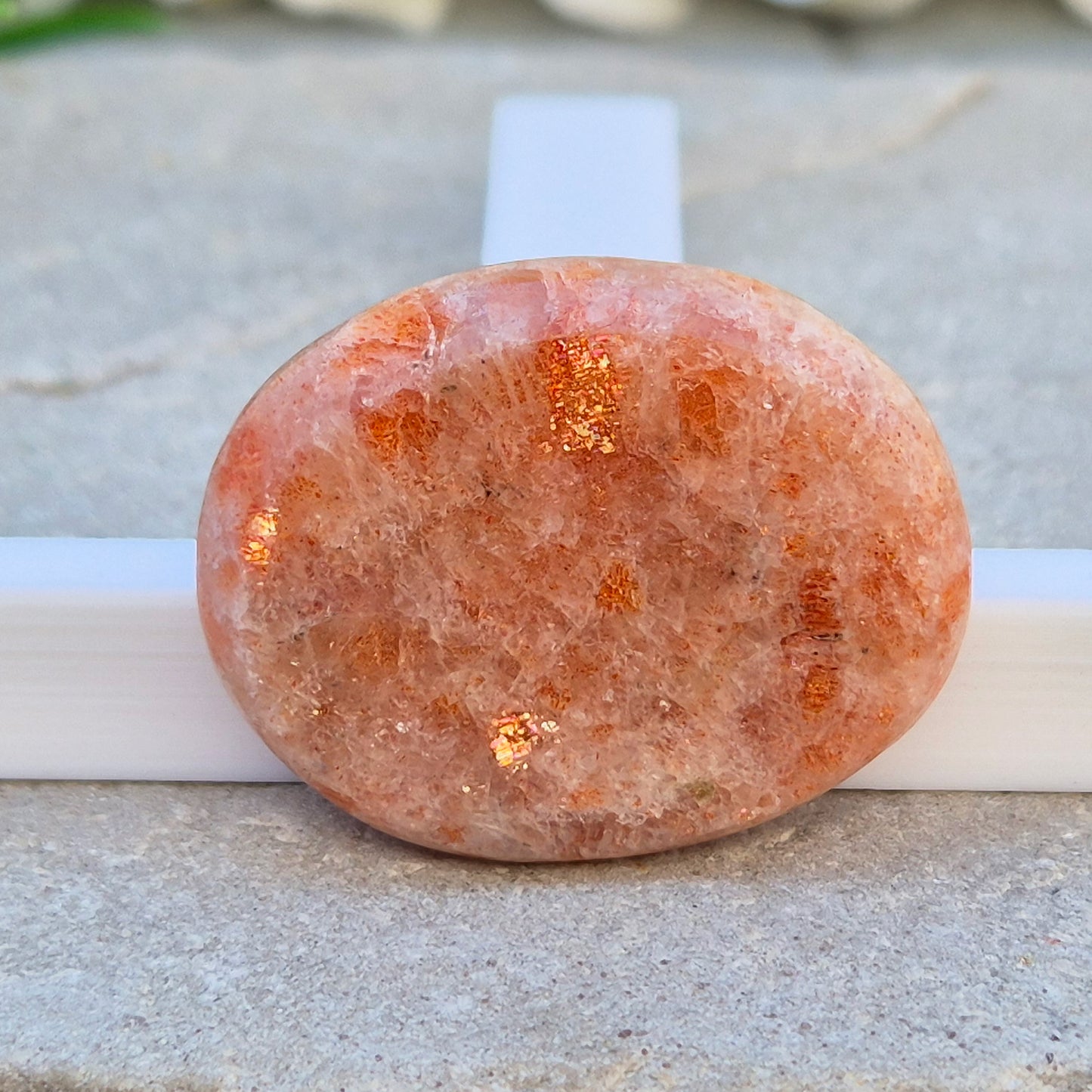 This flat, oval Sunstone palm stone carries soft peachy-orange tones and sits smoothly in the hand. Small enough to slip into a pocket or bag — sunshine you can carry with you.