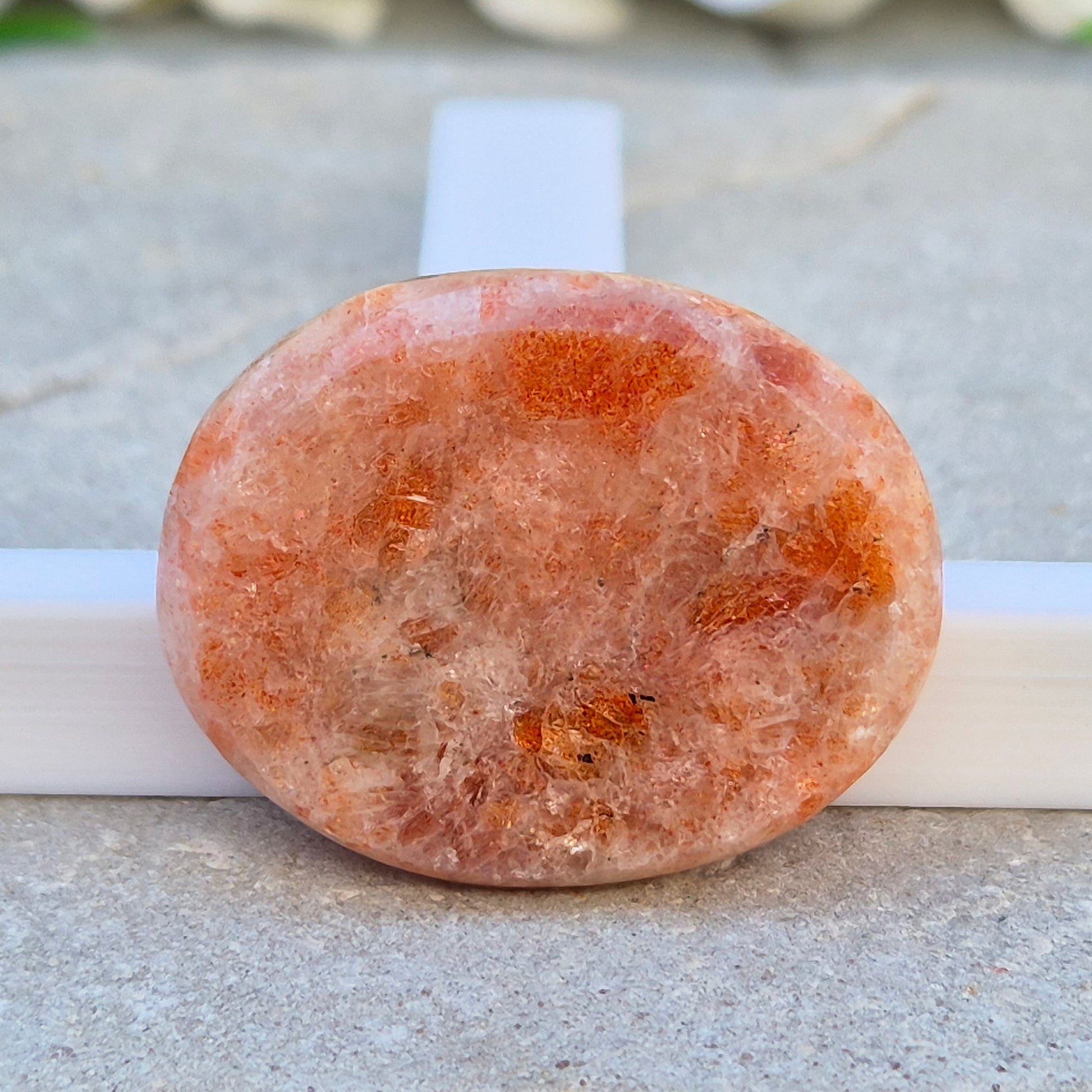 This flat, oval Sunstone palm stone carries soft peachy-orange tones and sits smoothly in the hand. Small enough to slip into a pocket or bag — sunshine you can carry with you.