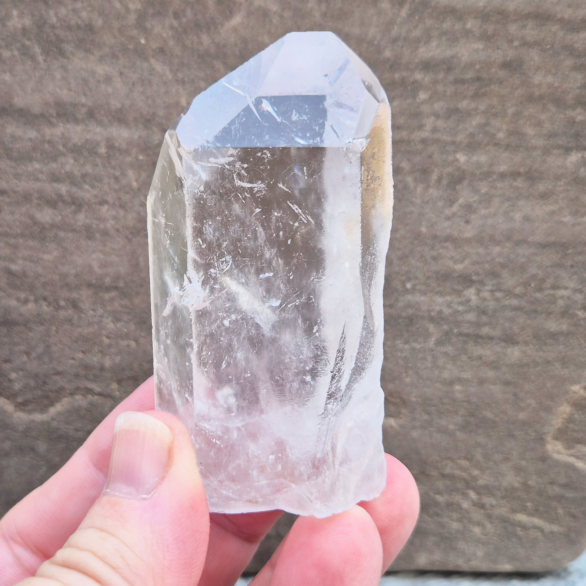 This Natural Quartz Crystal Point comes from Brazil and has a nice clear transparent tip and some interesting markings on one side.