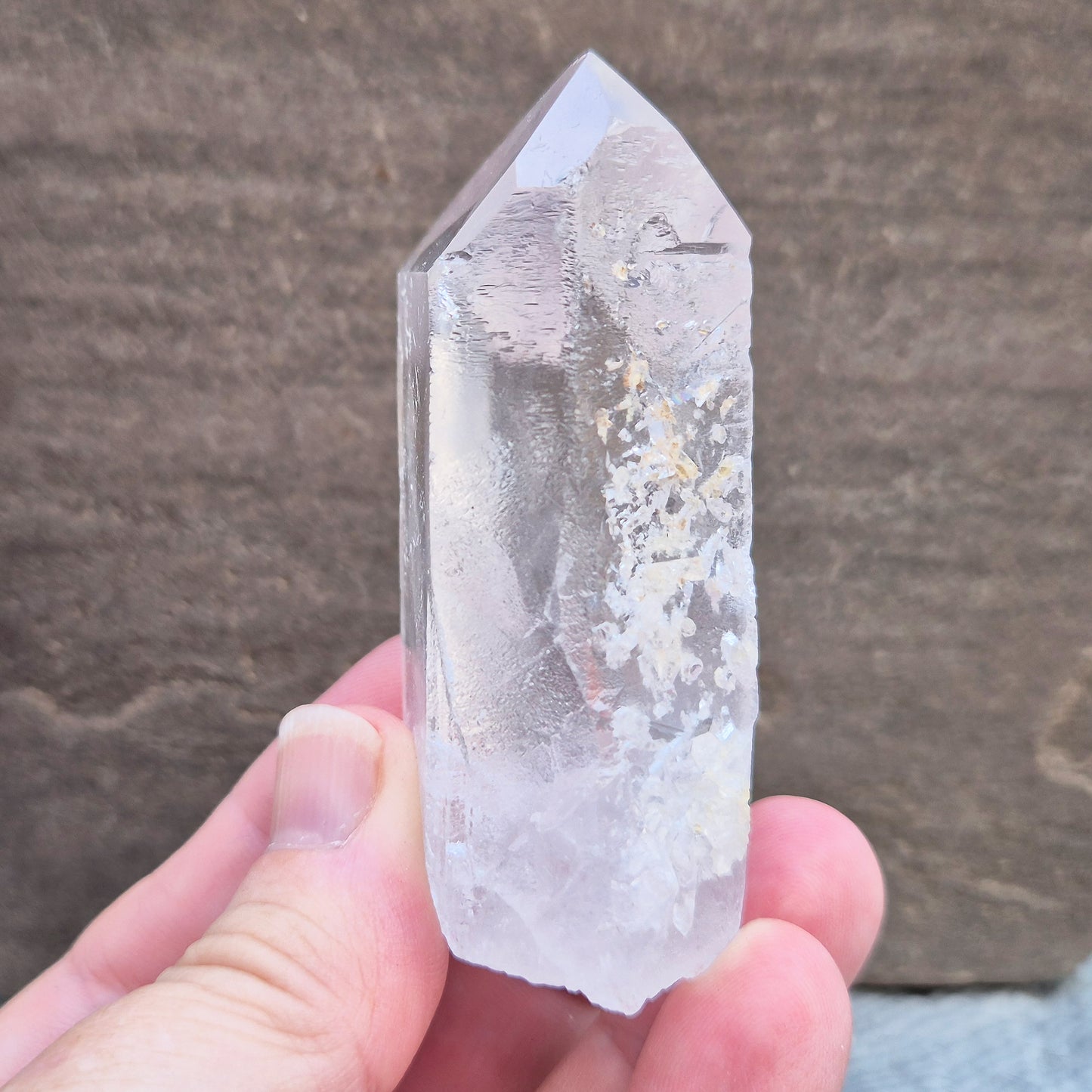 This Natural Quartz Crystal Point comes from Brazil and has a nice clear transparent tip and some interesting markings on one side.
