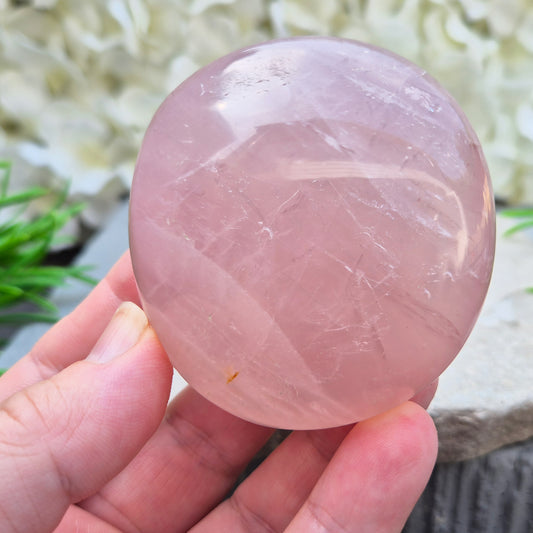 Large polished Rose Quartz palm stone with soft pink colouring and a smooth, rounded shape designed to sit naturally and comfortably in the hand.