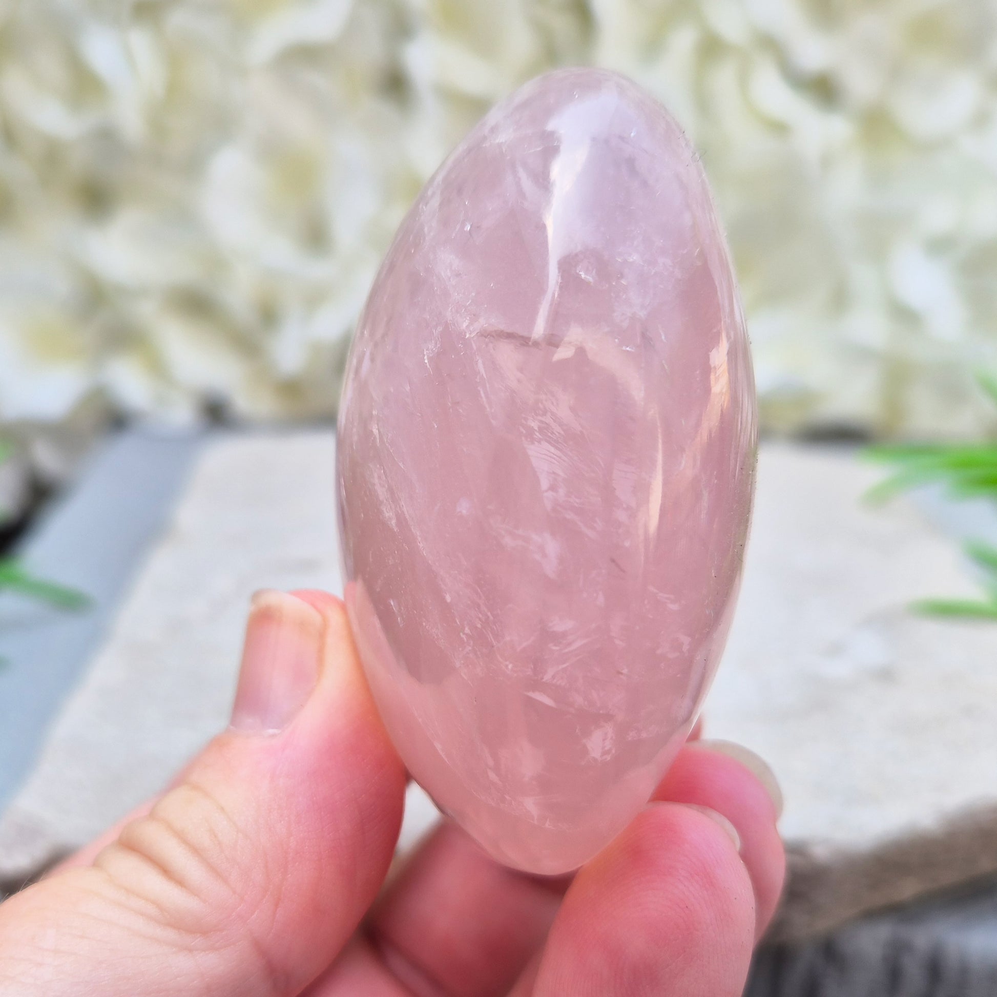 Large polished Rose Quartz palm stone with soft pink colouring and a smooth, rounded shape designed to sit naturally and comfortably in the hand.