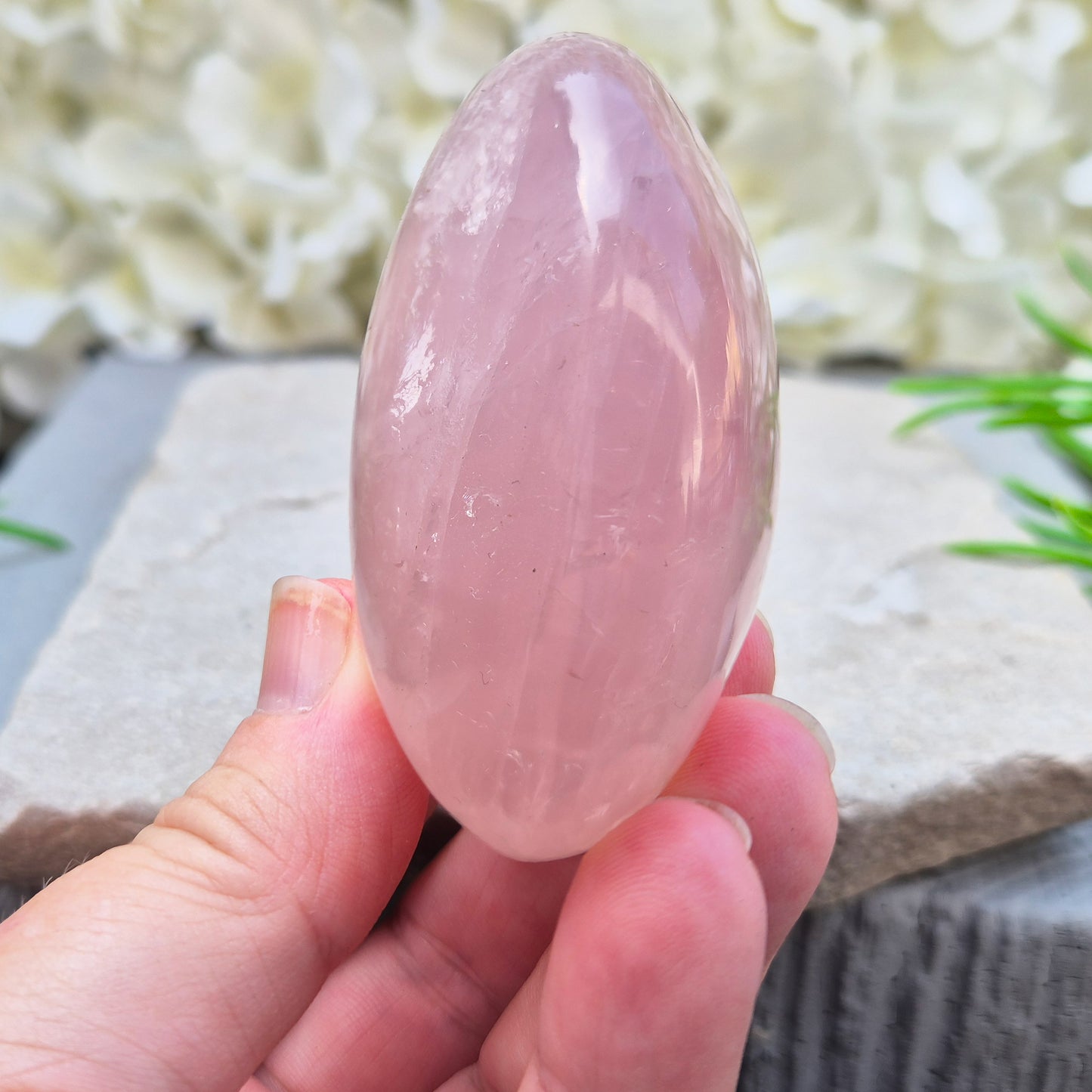 Large polished Rose Quartz palm stone with soft pink colouring and a smooth, rounded shape designed to sit naturally and comfortably in the hand.