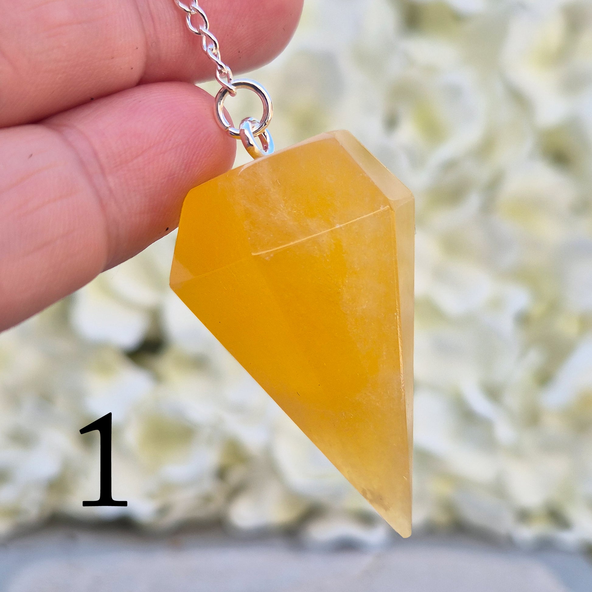 Polished Orange Calcite crystal pendulum on a silver colour chain, perfect for dowsing, decision-making, crystal healing, boosting creativity and energy work.