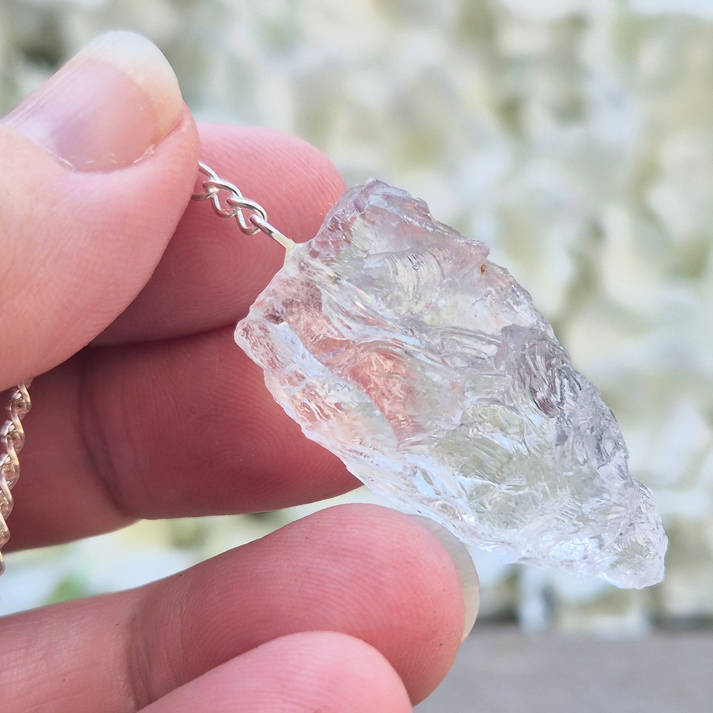 This Rock Quartz Crystal Pendulum from Brazil features a natural quartz crystal and a white bead at the end of the chain.&nbsp;It will come with a box or pouch for safe keeping. 