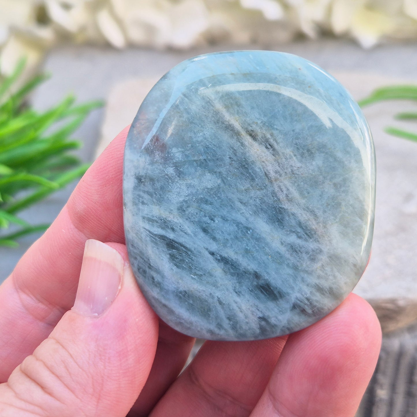 Aquamarine palm stone in pale aqua-blue, polished smooth. A calming crystal linked to the throat chakra, ideal for clearer thinking and honest conversations.
