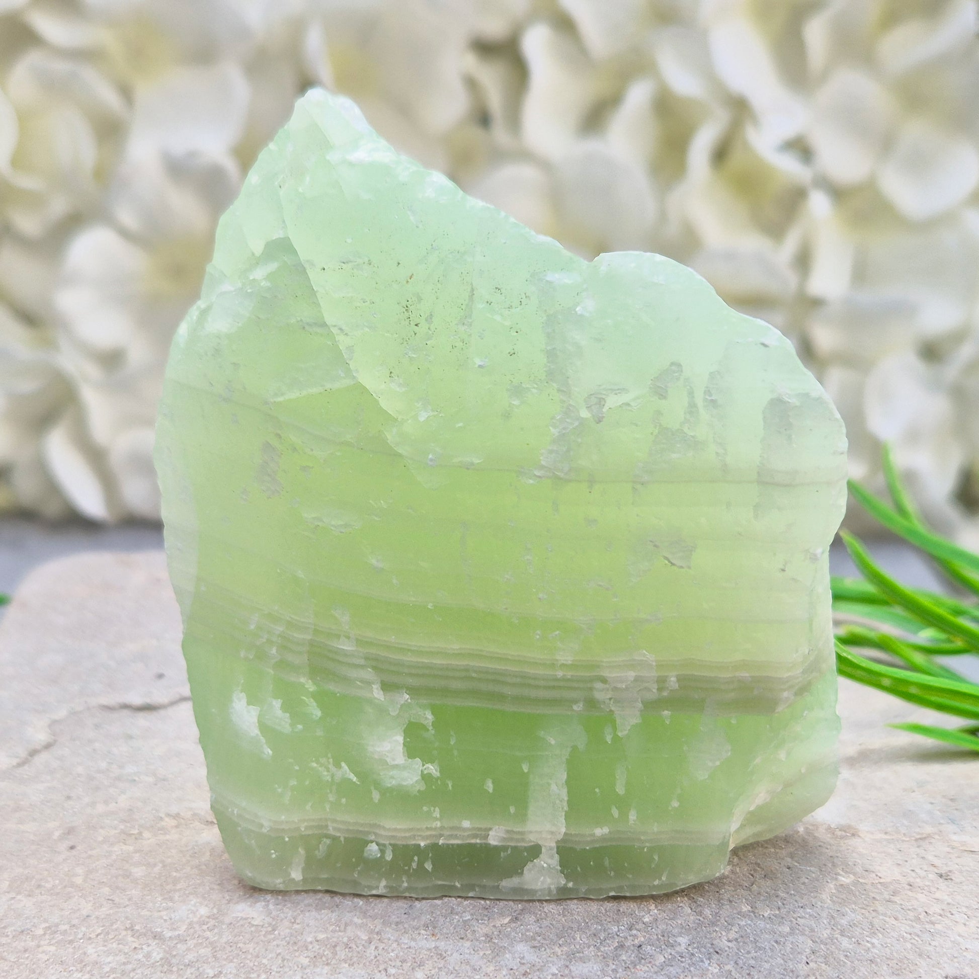 This natural self-standing Pistachio Calcite crystal comes from Pakistan and shows soft pale green to pistachio tones. This variety of Green Calcite gets its colouring from trace minerals embedded as the calcite formed.