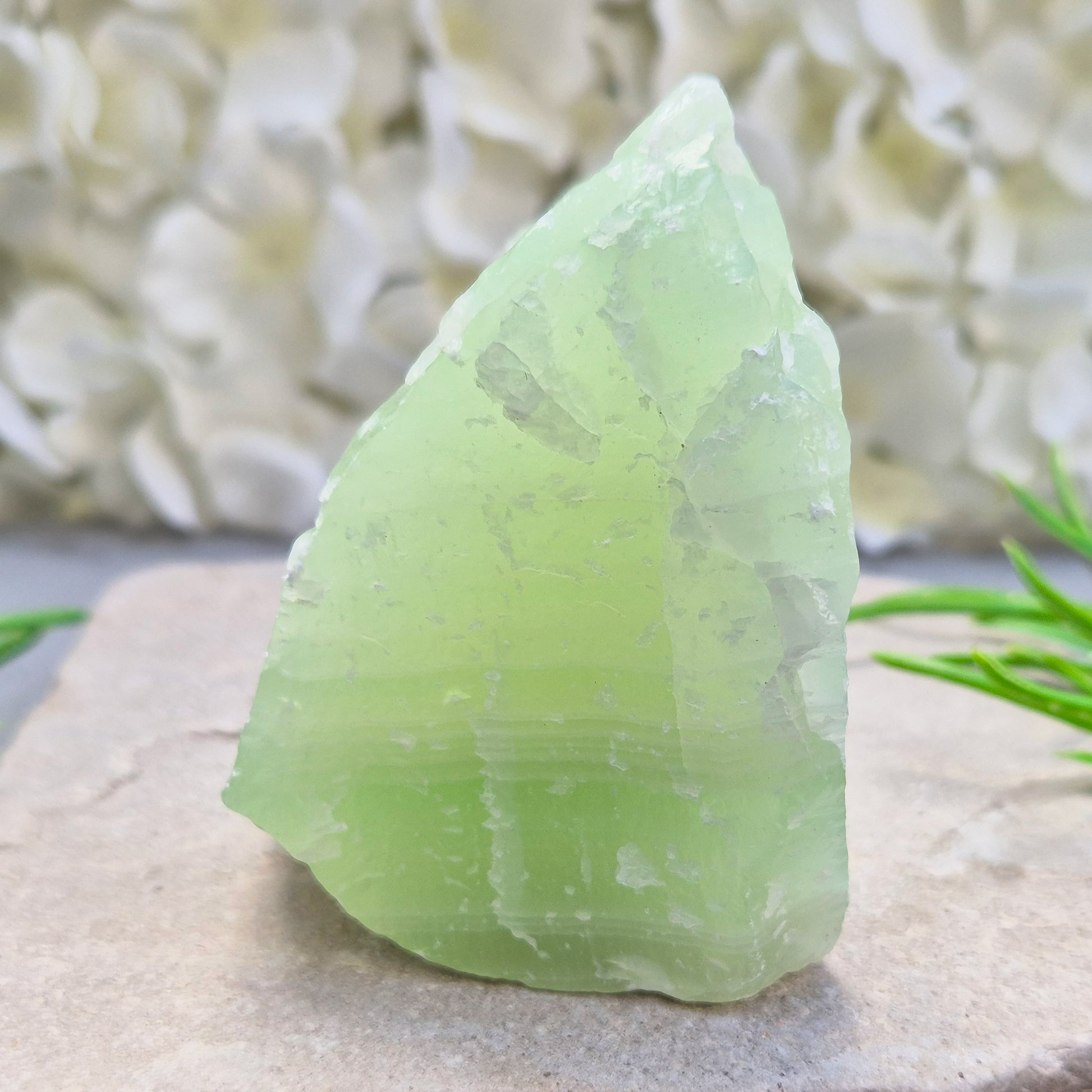 This natural self-standing Pistachio Calcite crystal comes from Pakistan and shows soft pale green to pistachio tones. This variety of Green Calcite gets its colouring from trace minerals embedded as the calcite formed.