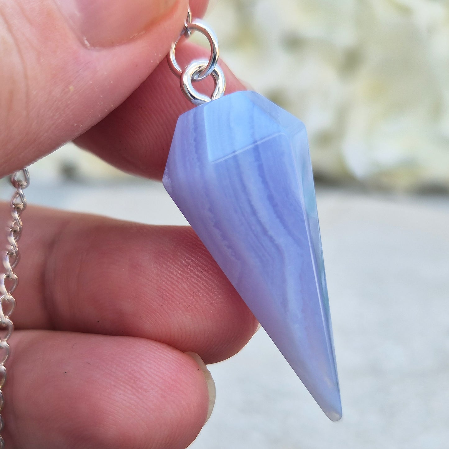 Blue Lace Agate crystal pendulum, known for its calming energy. Ideal for dowsing, spiritual guidance, and bringing a steady, peaceful feel.