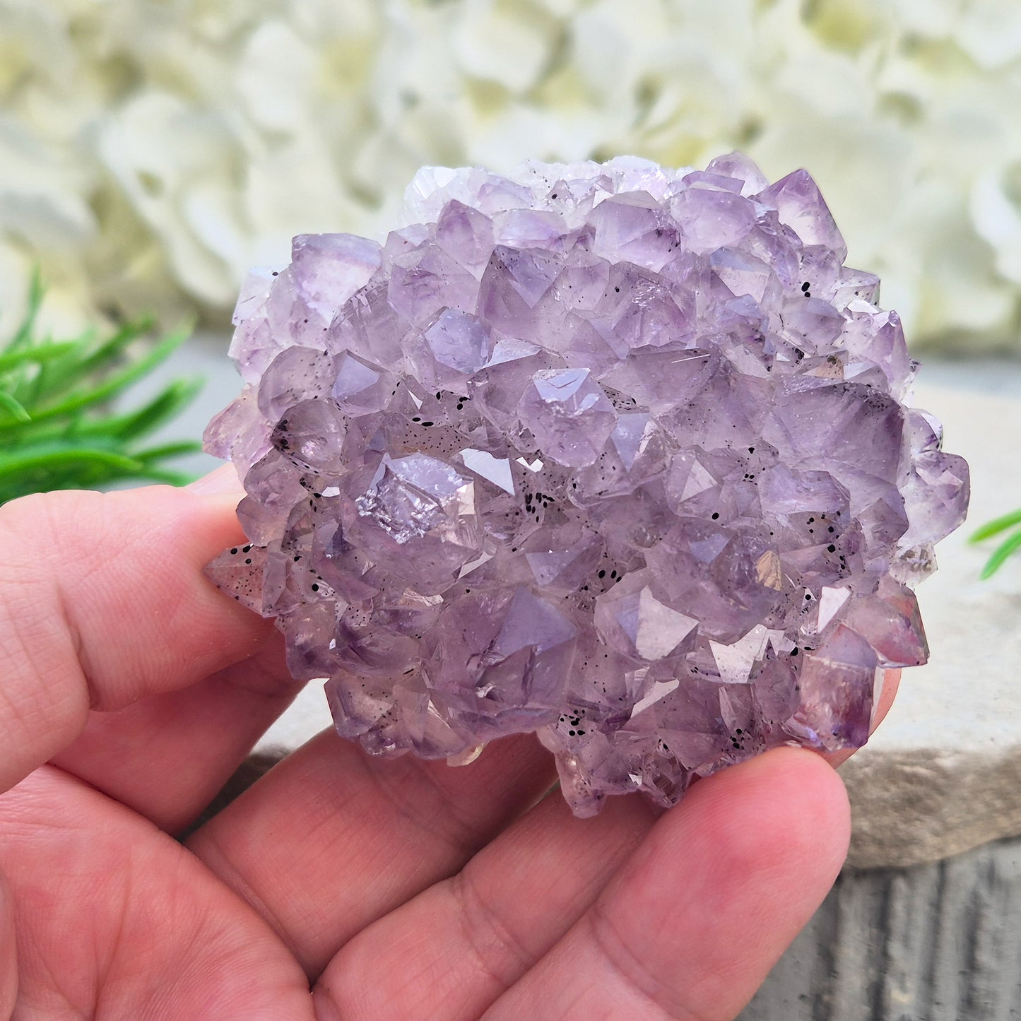 This amethyst stalactite cluster is formed from dozens of small pale amethyst crystal points densely packed into a rounded dome. Turned over, the base reveals a cross-section of the stalactite's growth, with the points radiating outward around a central core in a rosette-like pattern.