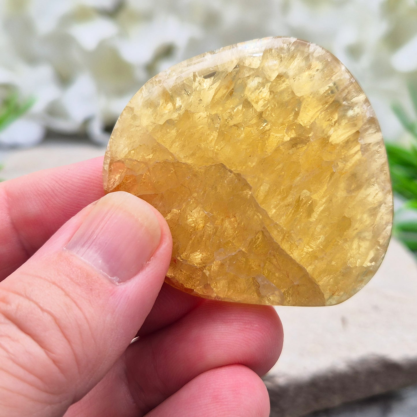 Honey Calcite Crystal Palm Stone, sometimes refered to as Golden Calcite or Amber Calcite. A smooth, pocket-sized palm stone in warm honey-gold tones, ranging from pale lemon-yellow to deep amber.