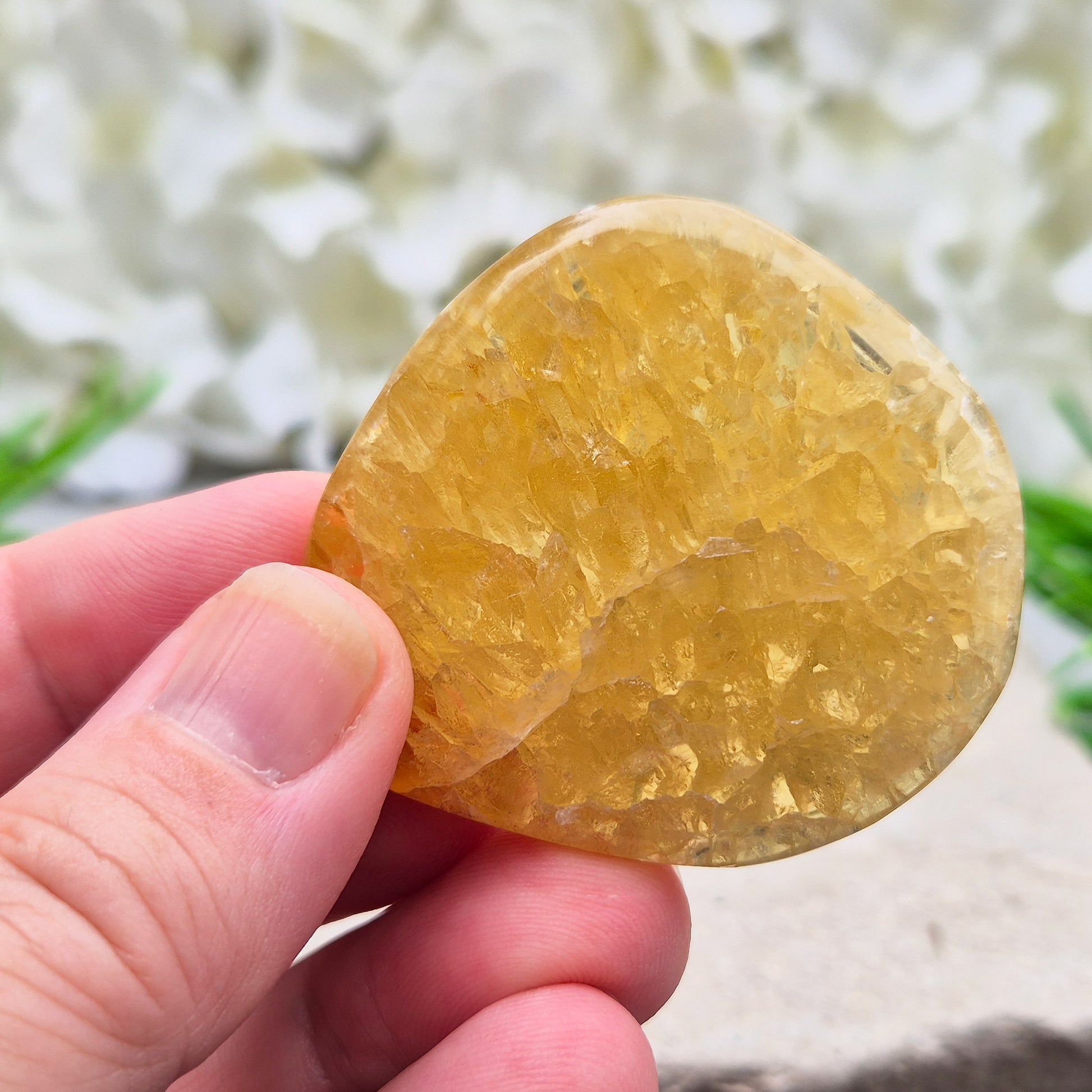 Honey Calcite Crystal Palm Stone, sometimes refered to as Golden Calcite or Amber Calcite. A smooth, pocket-sized palm stone in warm honey-gold tones, ranging from pale lemon-yellow to deep amber.
