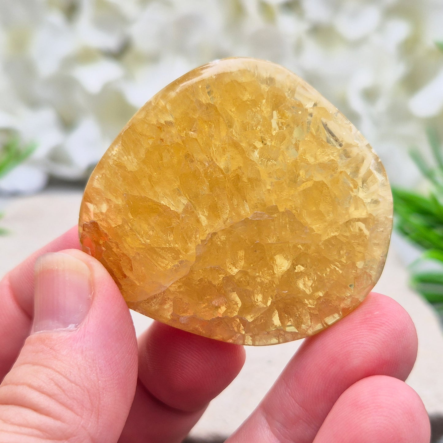 Honey Calcite Crystal Palm Stone, sometimes refered to as Golden Calcite or Amber Calcite. A smooth, pocket-sized palm stone in warm honey-gold tones, ranging from pale lemon-yellow to deep amber.