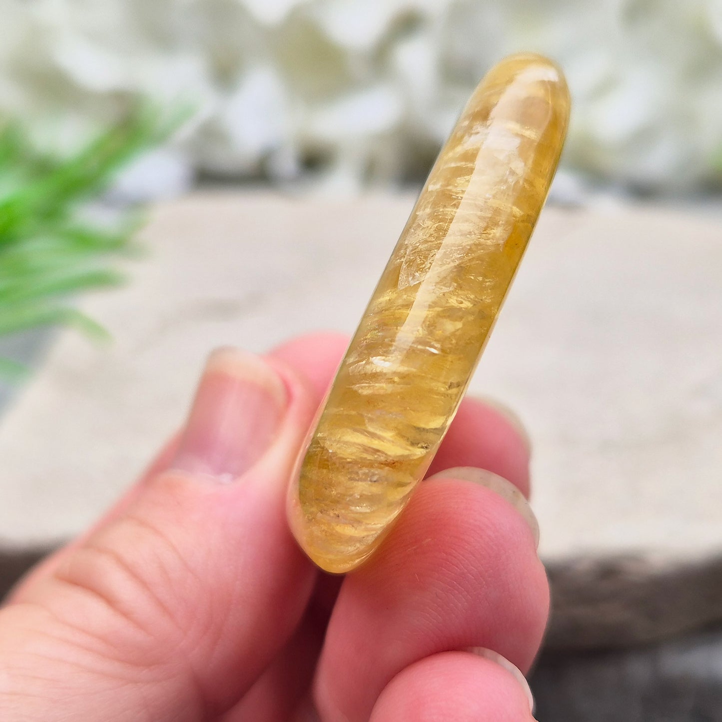 Honey Calcite Crystal Palm Stone, sometimes refered to as Golden Calcite or Amber Calcite. A smooth, pocket-sized palm stone in warm honey-gold tones, ranging from pale lemon-yellow to deep amber.